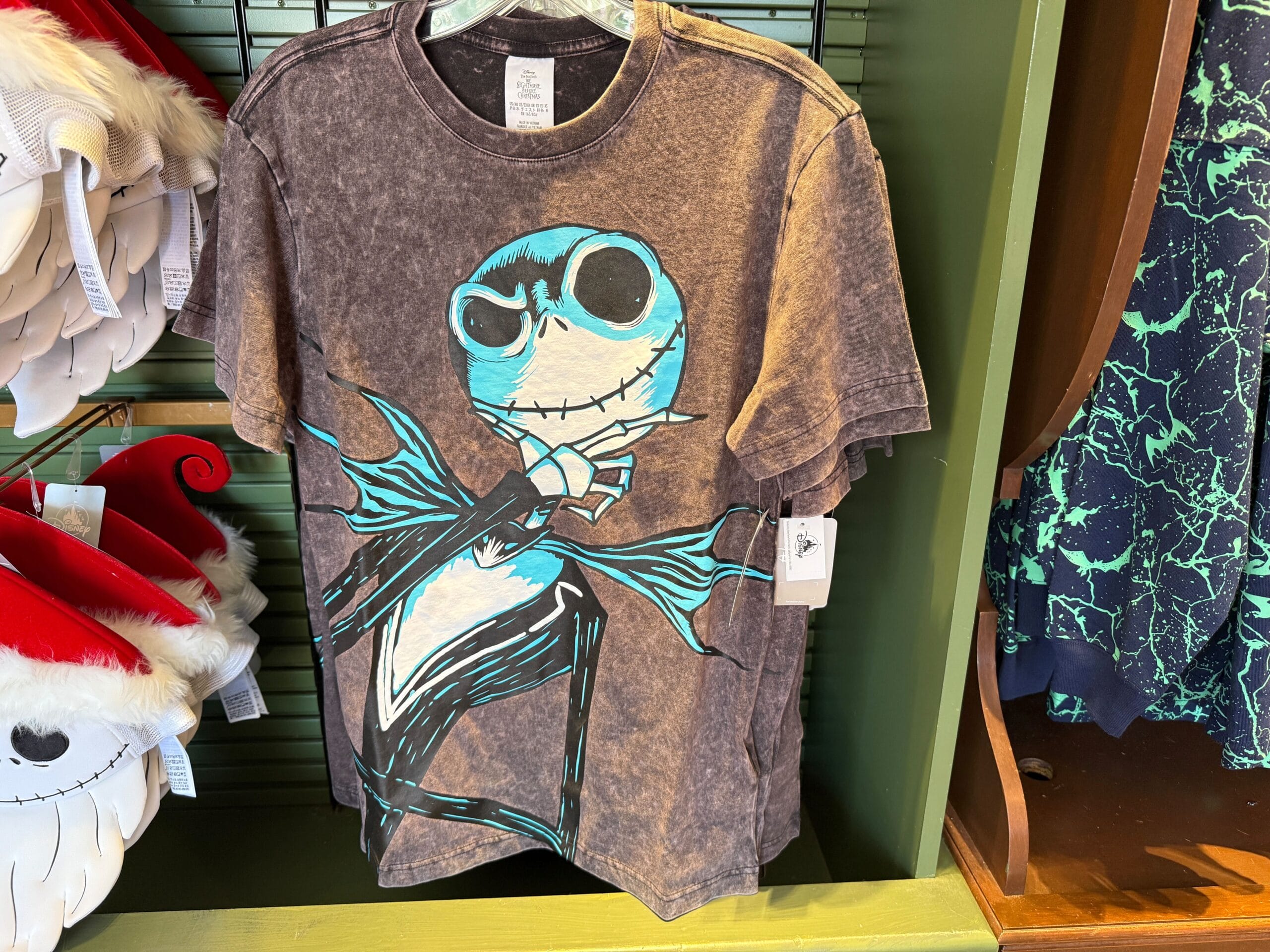 Black t-shirt featuring The Nightmare Before Christmas Jack Skellington graphic with blue accents, hanging on a display rack.