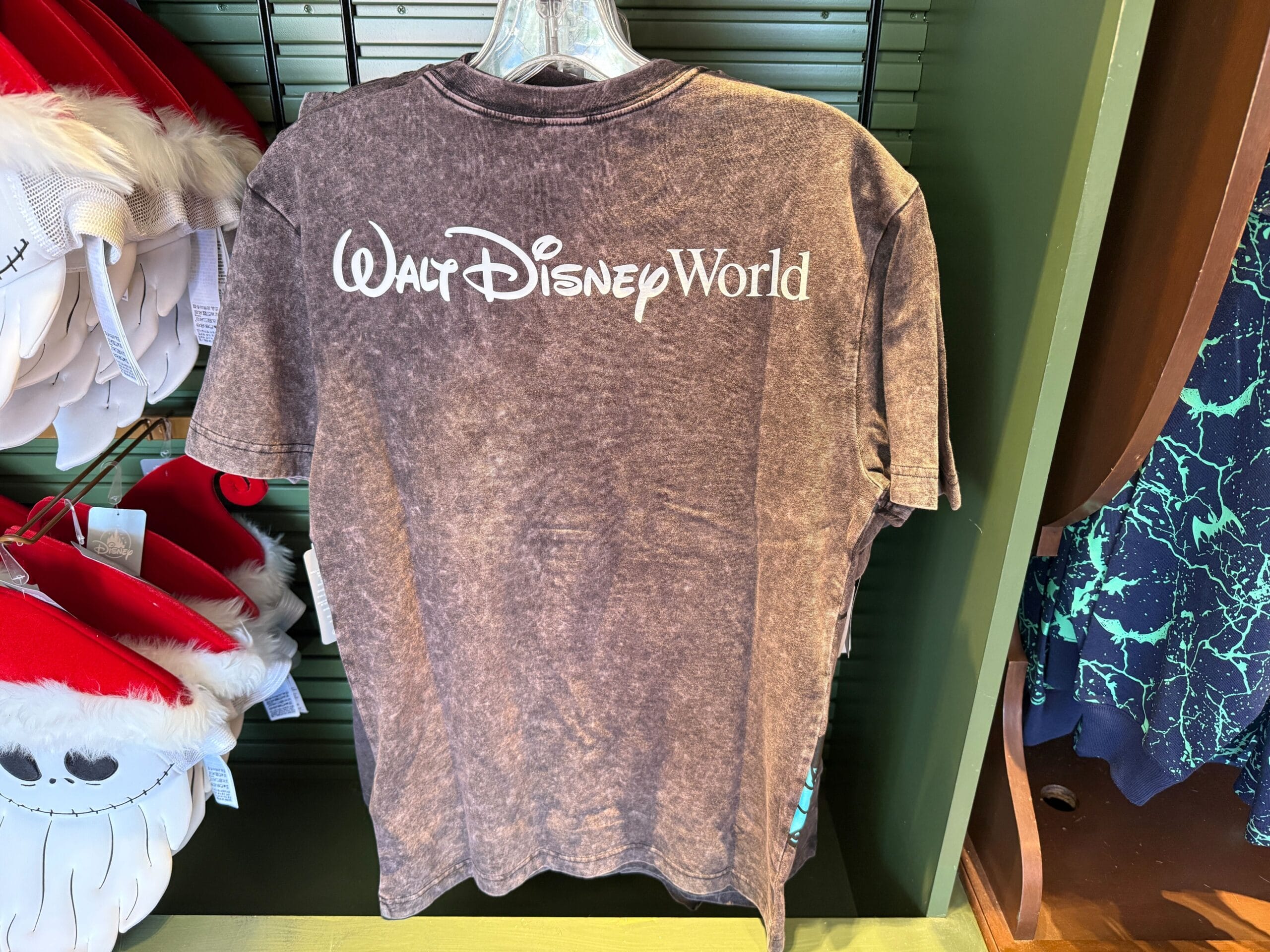 A faded brown T-shirt on a rack with “Walt Disney World” and new Nightmare Before Christmas merchandise nearby.