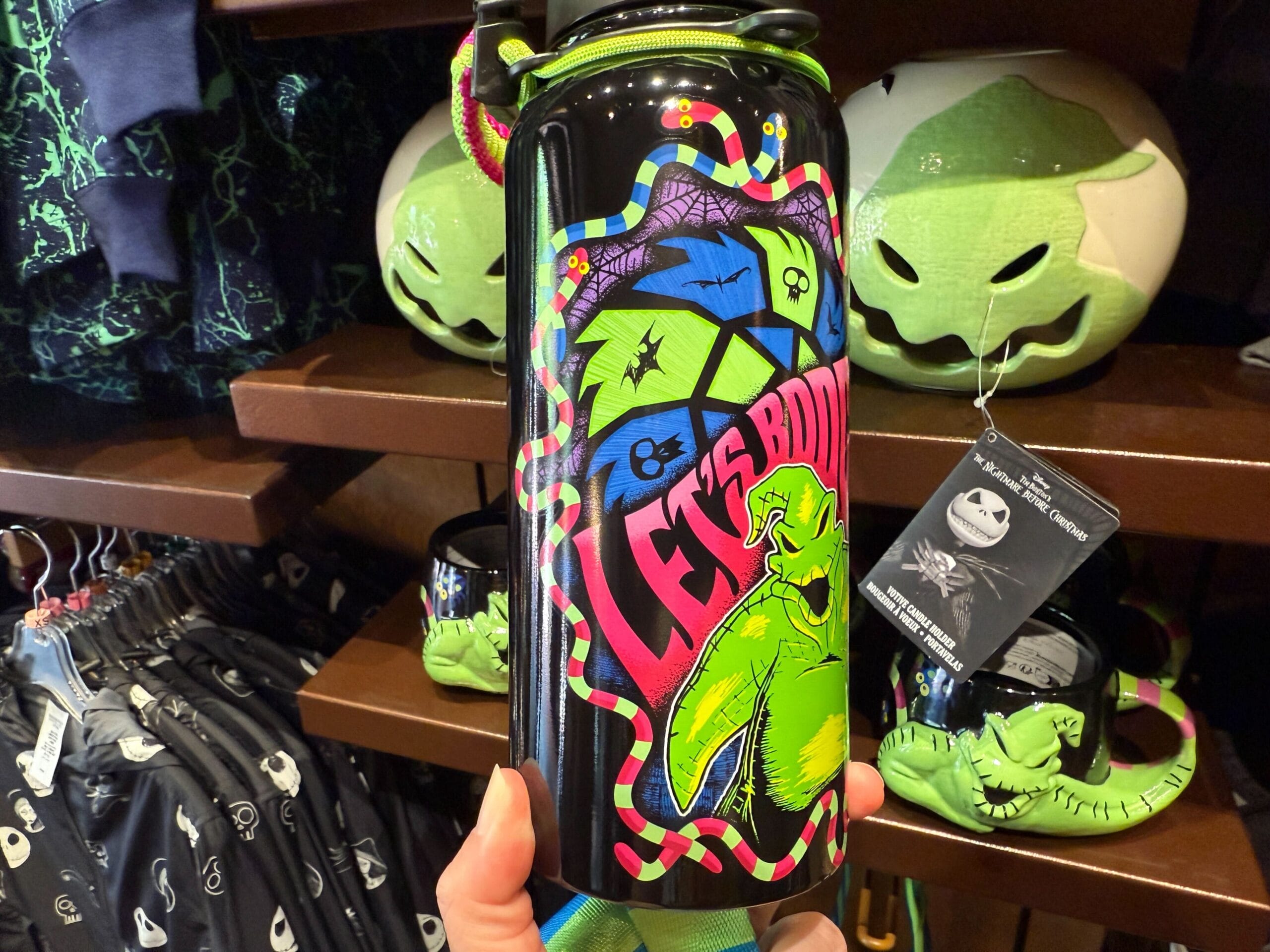 A colorful "Let's Boogie" water bottle featuring The Nightmare Before Christmas merchandise in a store display.