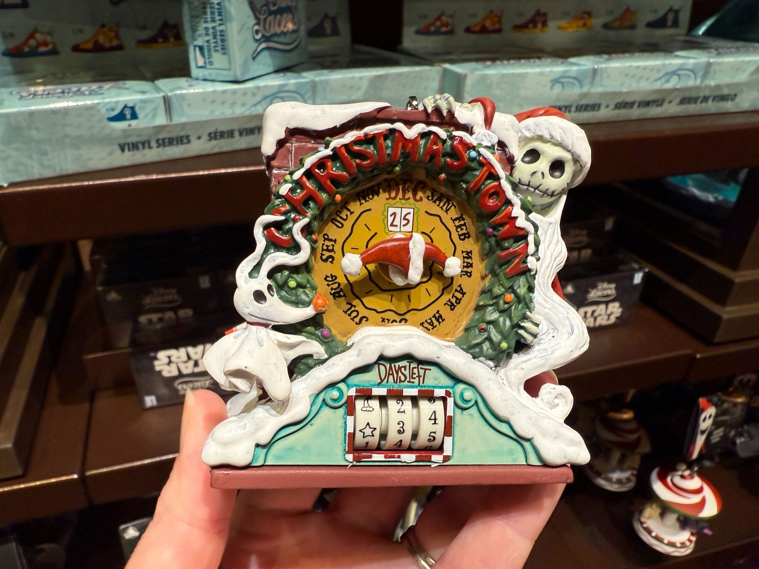 A hand holds The Nightmare Before Christmas merchandise: a Town countdown calendar set to 25 days until Christmas.