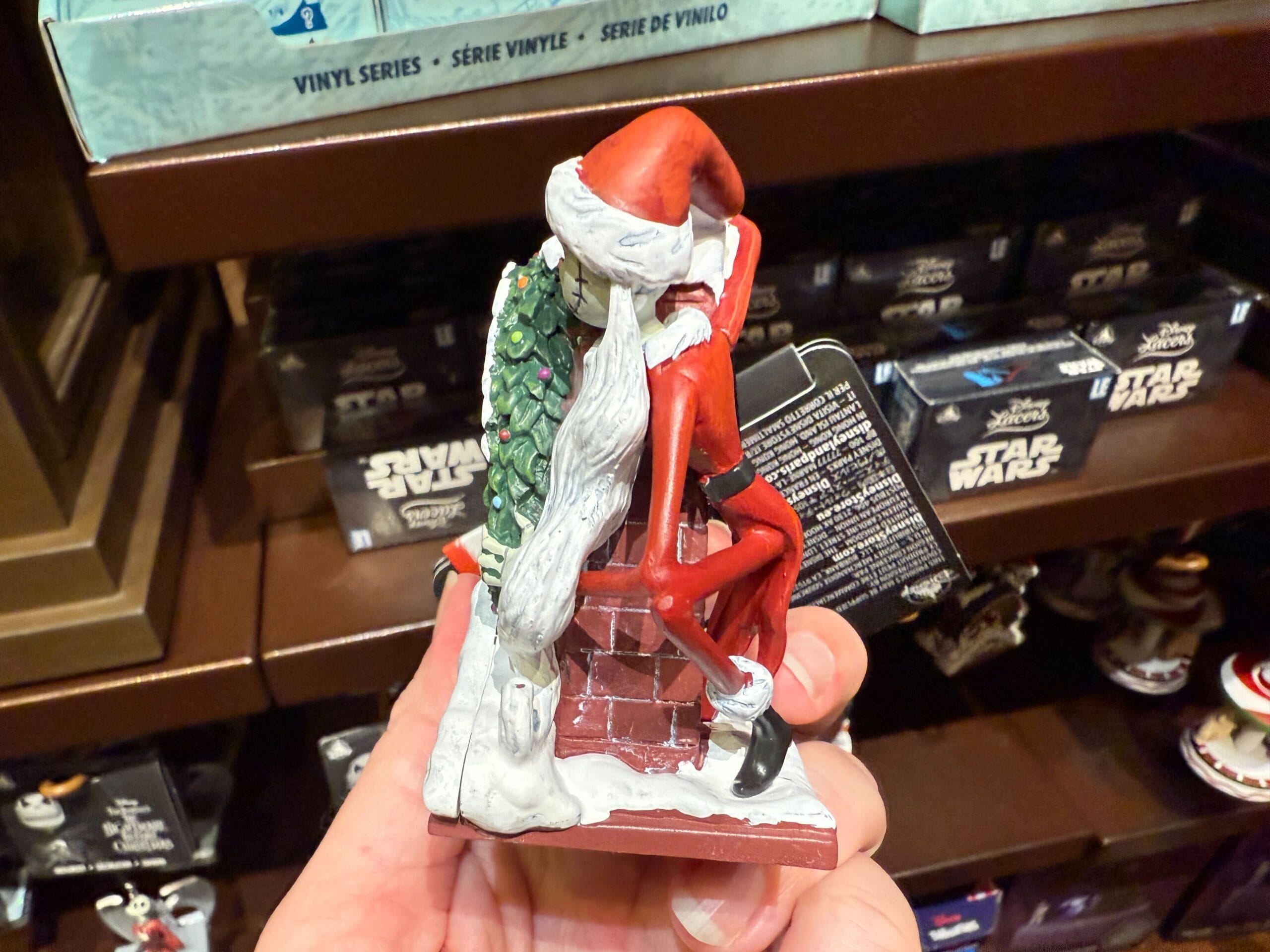 A The Nightmare Before Christmas figurine of Jack Skellington as Santa sits on a chimney, perfect holiday merchandise.