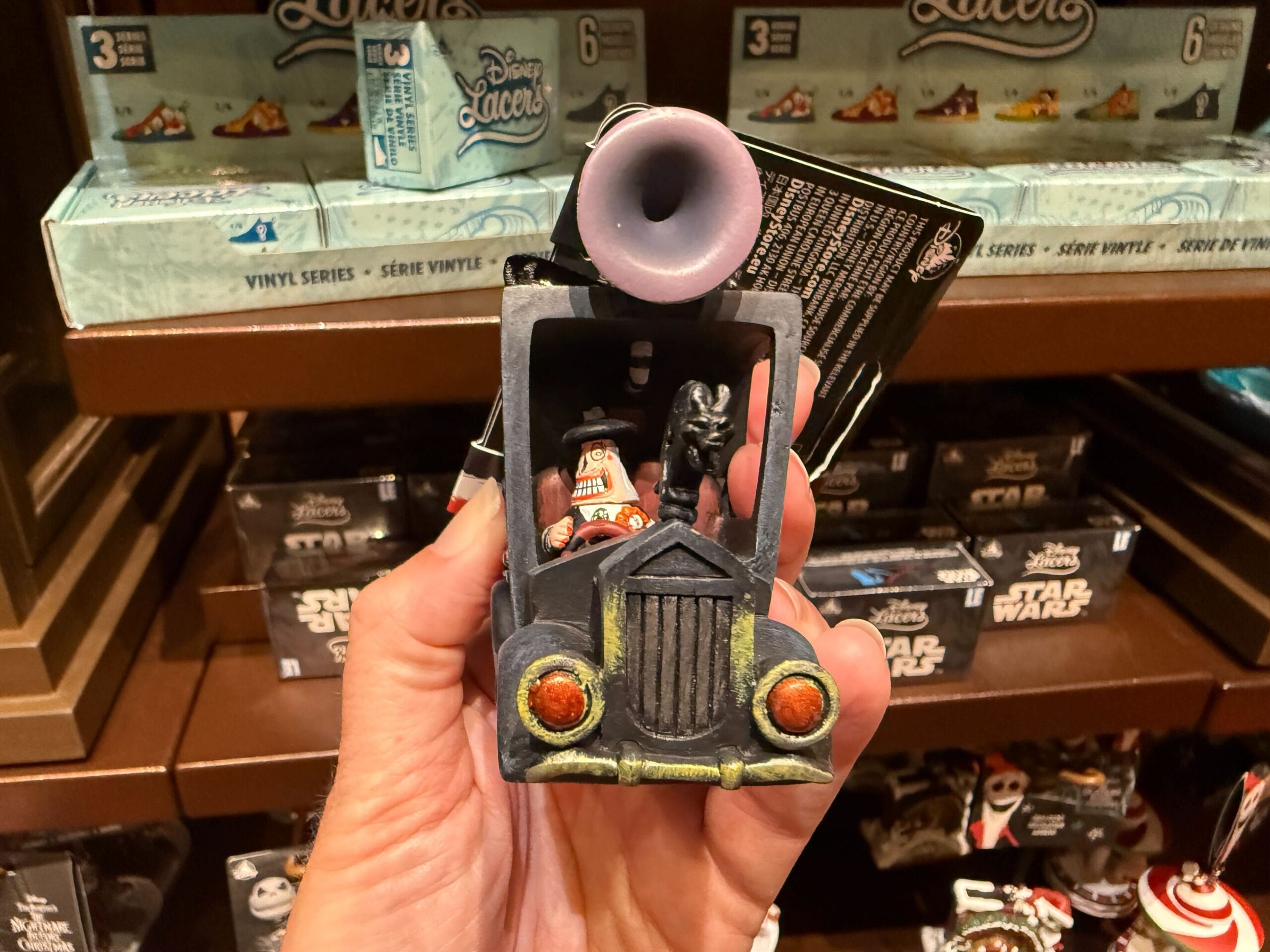 A hand holds Haunted Mansion merchandise with Star Wars characters inside, inspired by The Nightmare Before Christmas.