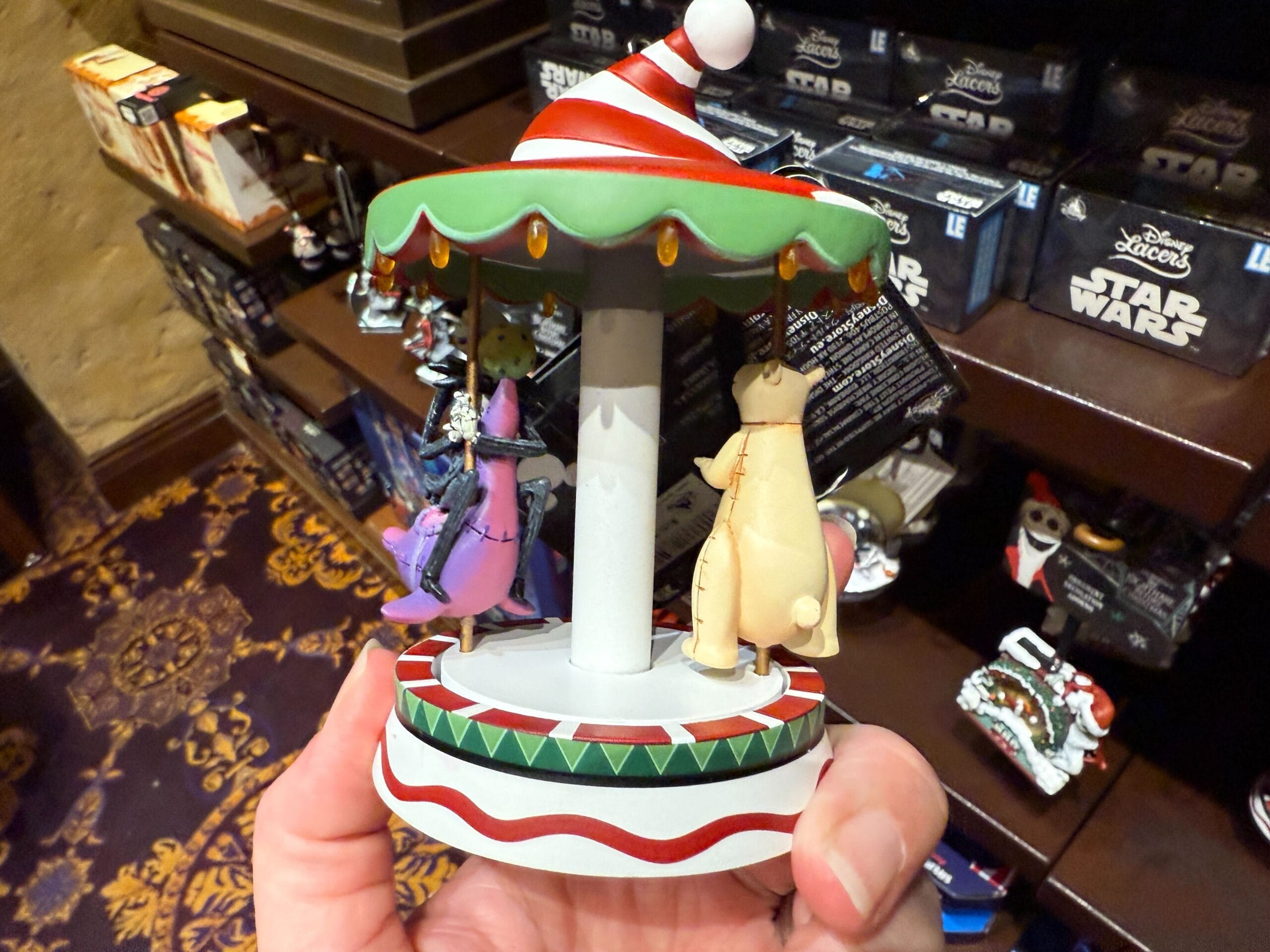 Hand holding new The Nightmare Before Christmas carousel ornament—perfect merchandise for holiday décor.