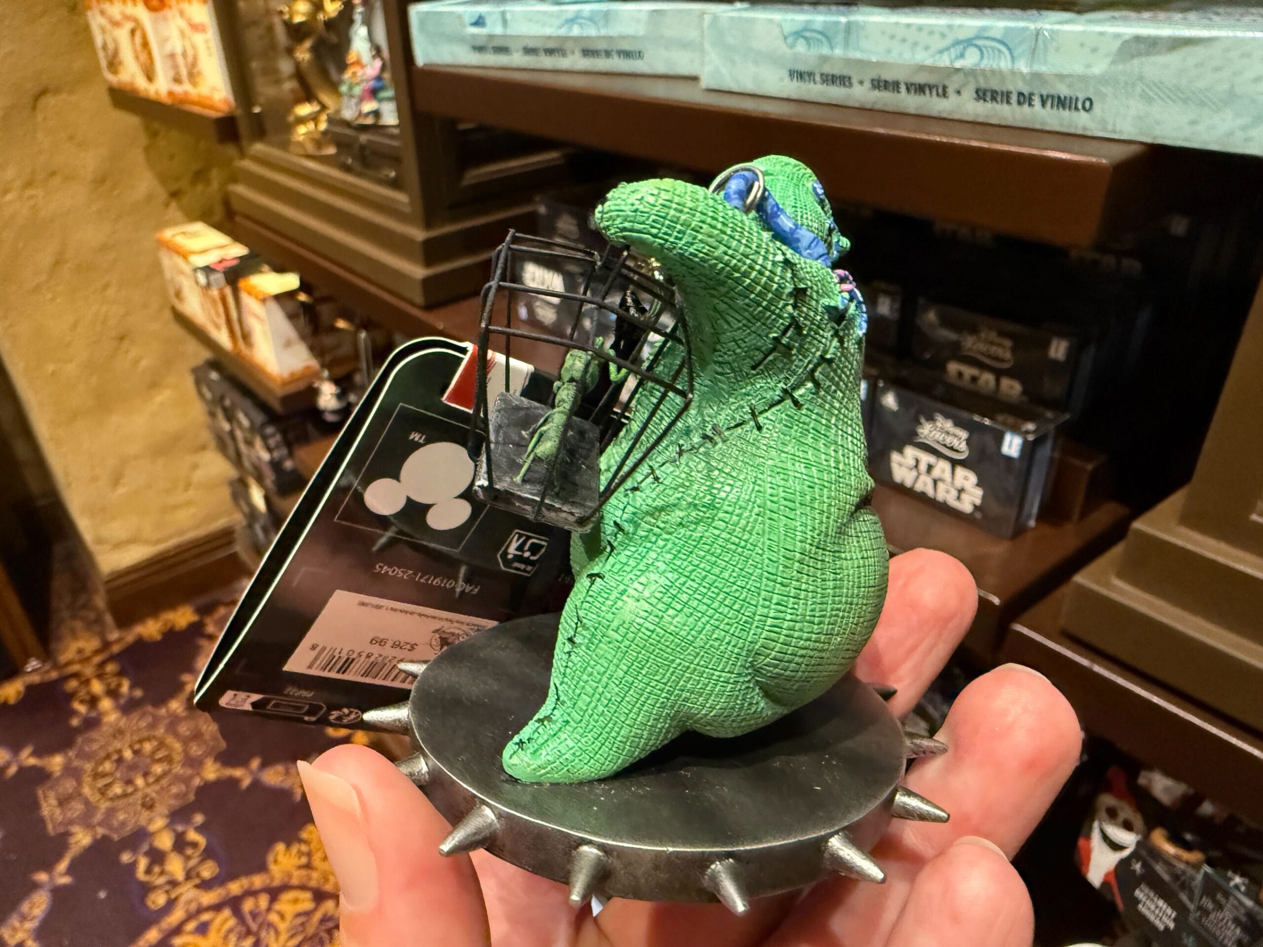 A hand holds new Nightmare Before Christmas Oogie Boogie plush, displayed among Star Wars merchandise in a store.