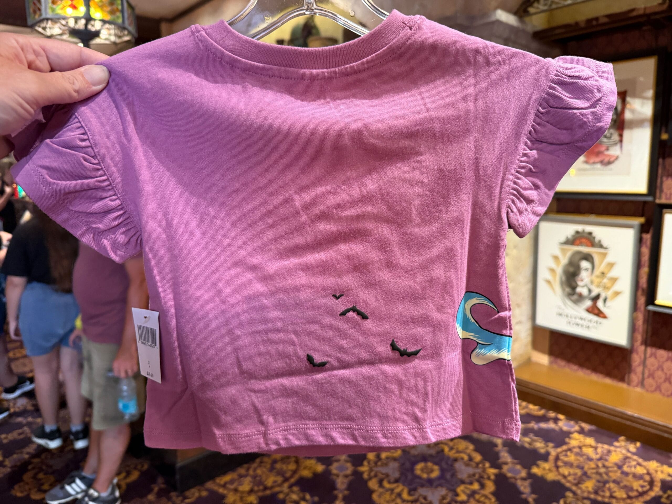 A pink toddler t-shirt with ruffled sleeves, inspired by The Nightmare Before Christmas merchandise, featuring black bats.