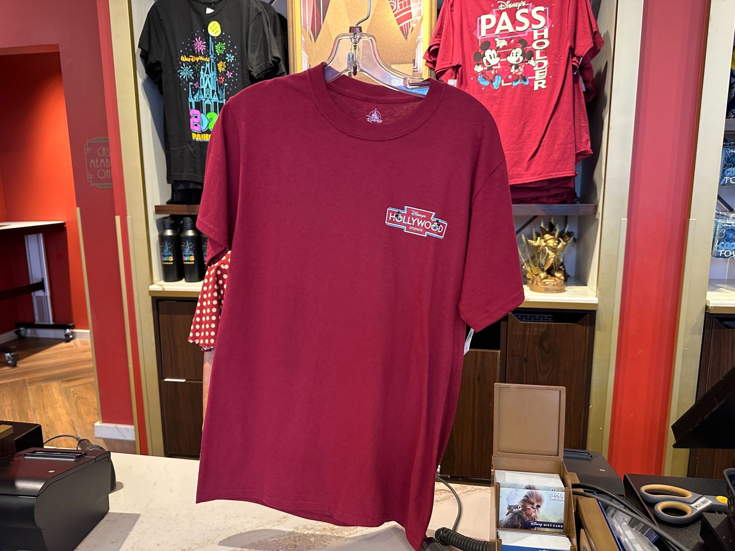 A maroon t-shirt with a “Disney’s Hollywood Studios” logo is featured among the latest WDW Merch in-store.