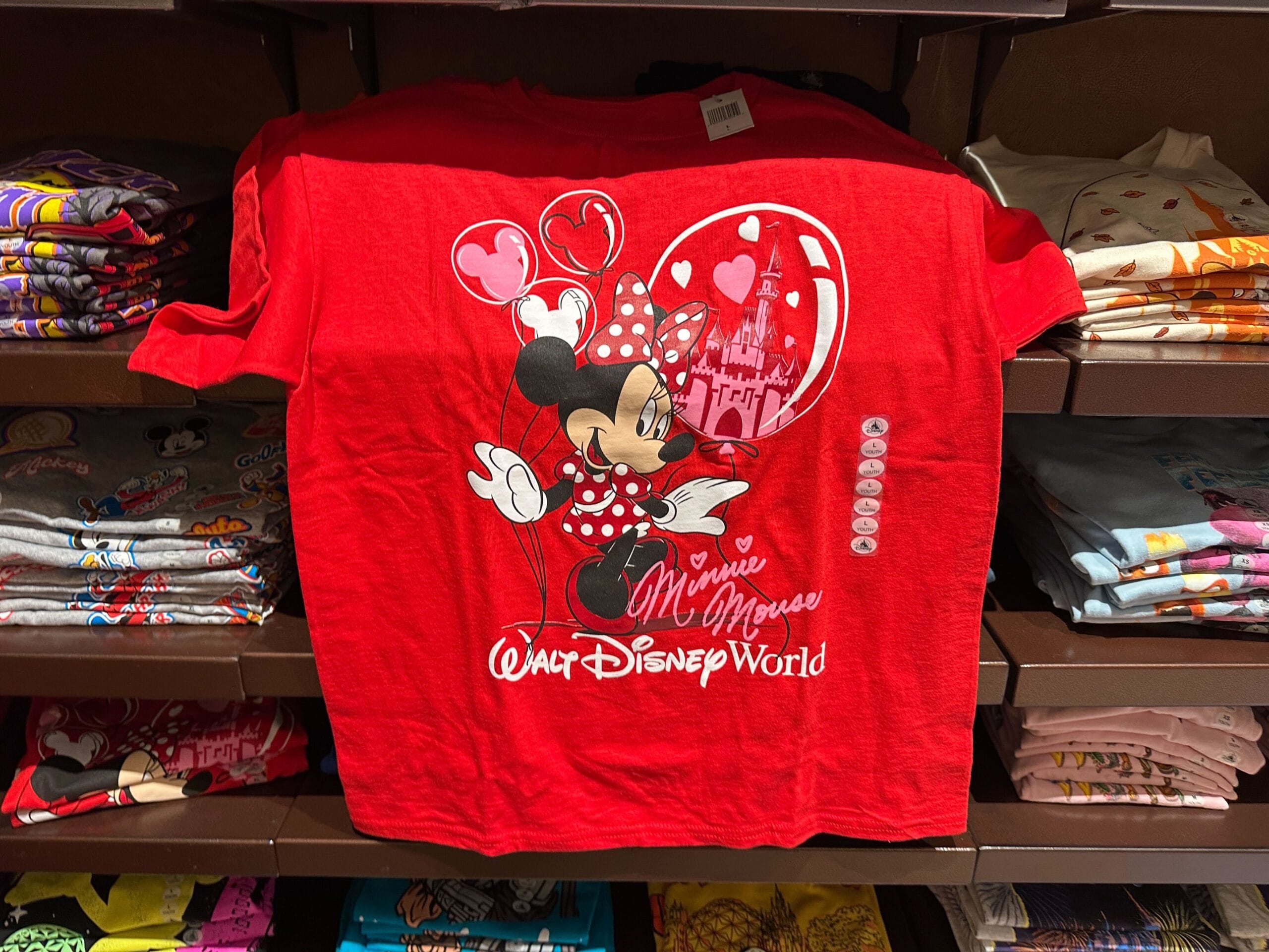 Red T-shirt featuring Minnie Mouse, balloons, a castle, and "Walt Disney World"—a must-have Disney merchandise piece.