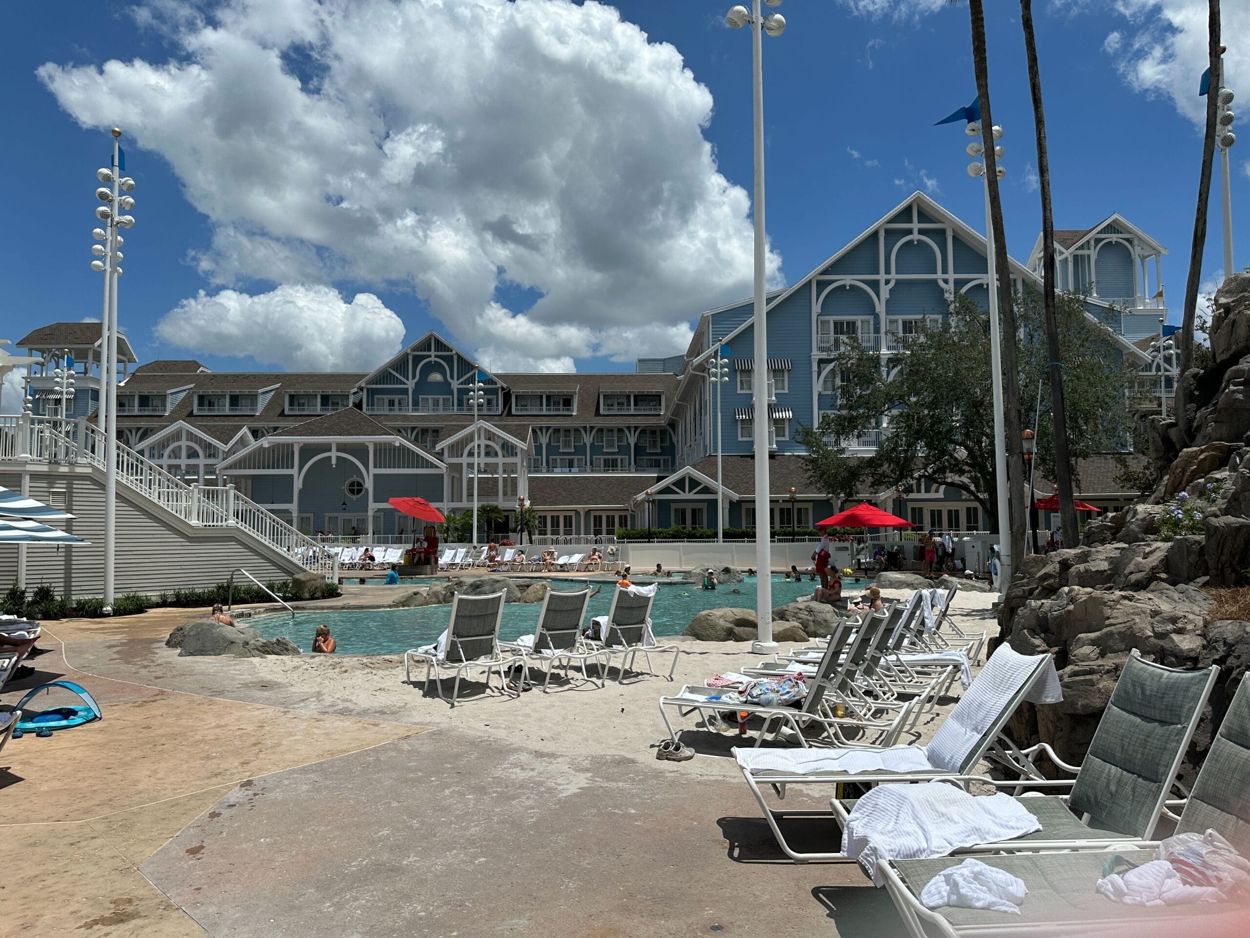 Outdoor hotel pool area with lounge chairs and umbrellas at Stormalong Bay, near Disney's Yacht Club & Beach Club Resorts.