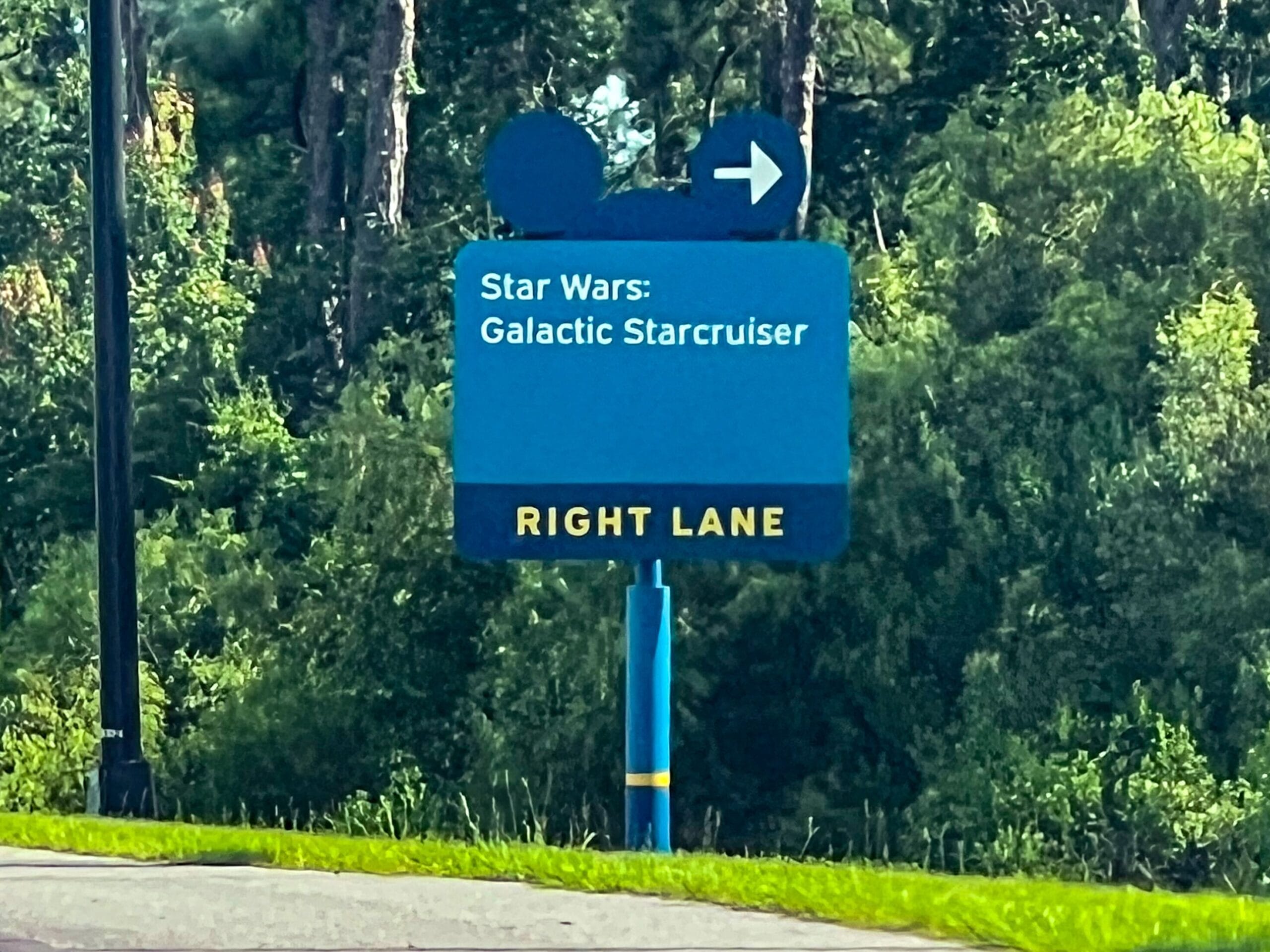 Blue road sign with a Mickey Mouse icon directs to "Star Wars: Galactic Starcruiser" in the right lane.