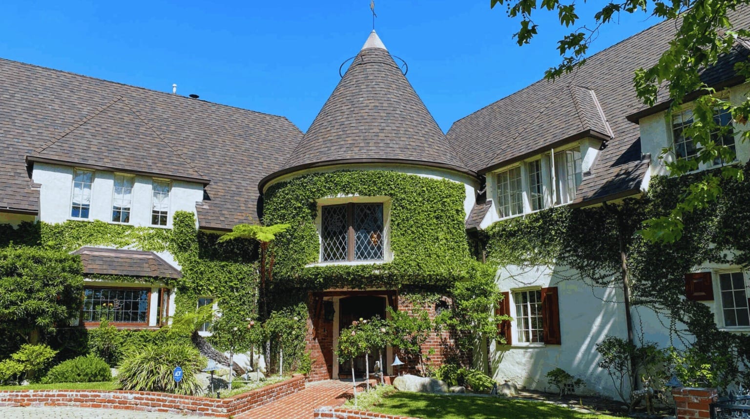 Los Feliz home with a turret, ivy-covered walls, and wooden door, exuding a Walt Disney fairytale charm.