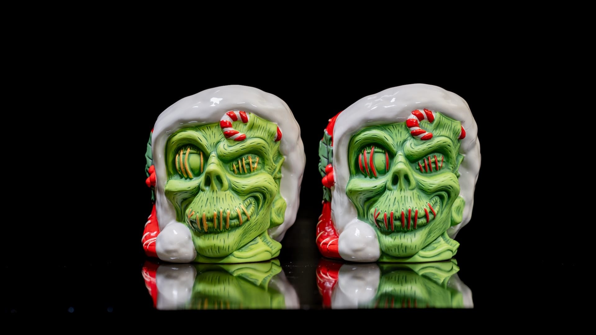 Two ceramic Holiday Zombie Head Mugs with green skin, inspired by Trader Sam's Enchanted Tiki Bar, against a black background.