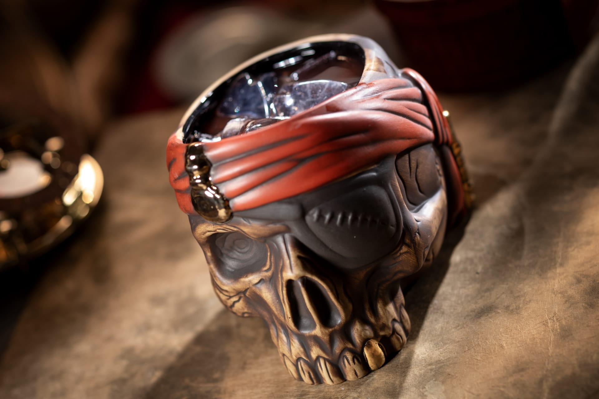 A skull-shaped mug with a red pirate bandana offers a first look at the Beak and Barrel menu under warm light.