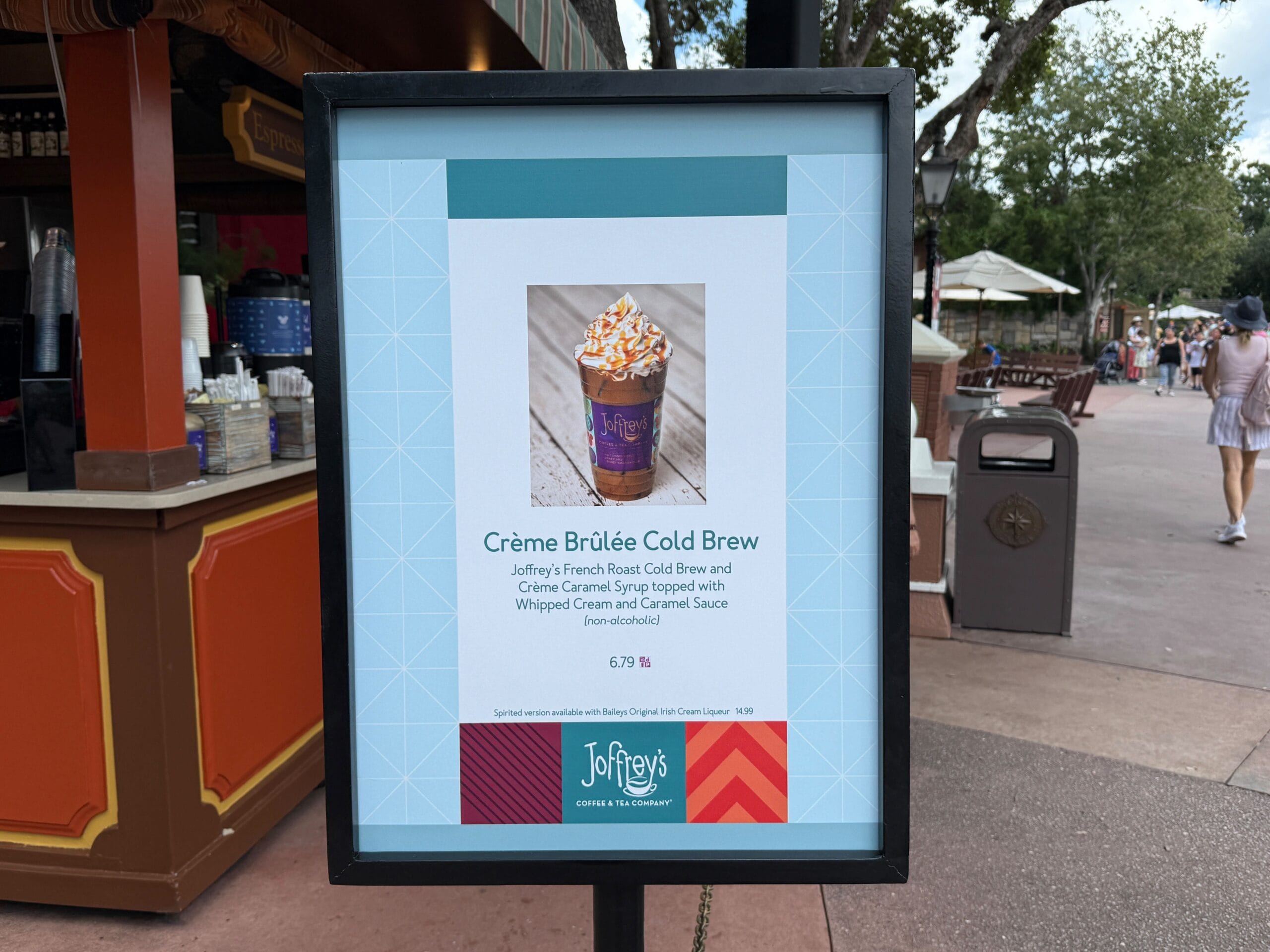 A sign displays Joffrey's Crème Brûlée Cold Brew, a New Food & Wine treat, with photo and description by a coffee stand.