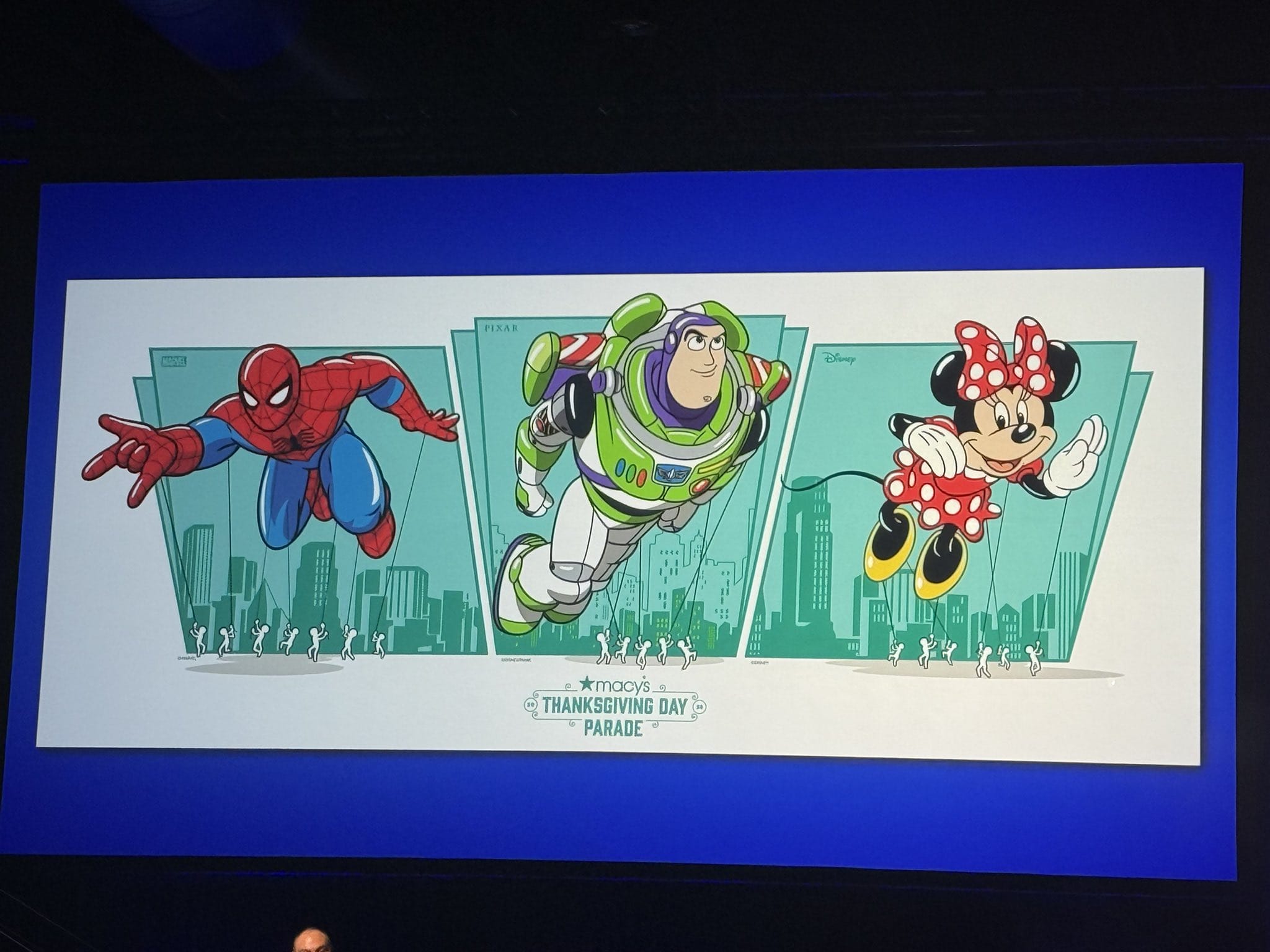 Illustration of Spider-Man, Minnie Mouse, and the Buzz Lightyear Balloon above a cityscape for Macy's Thanksgiving Day Parade.