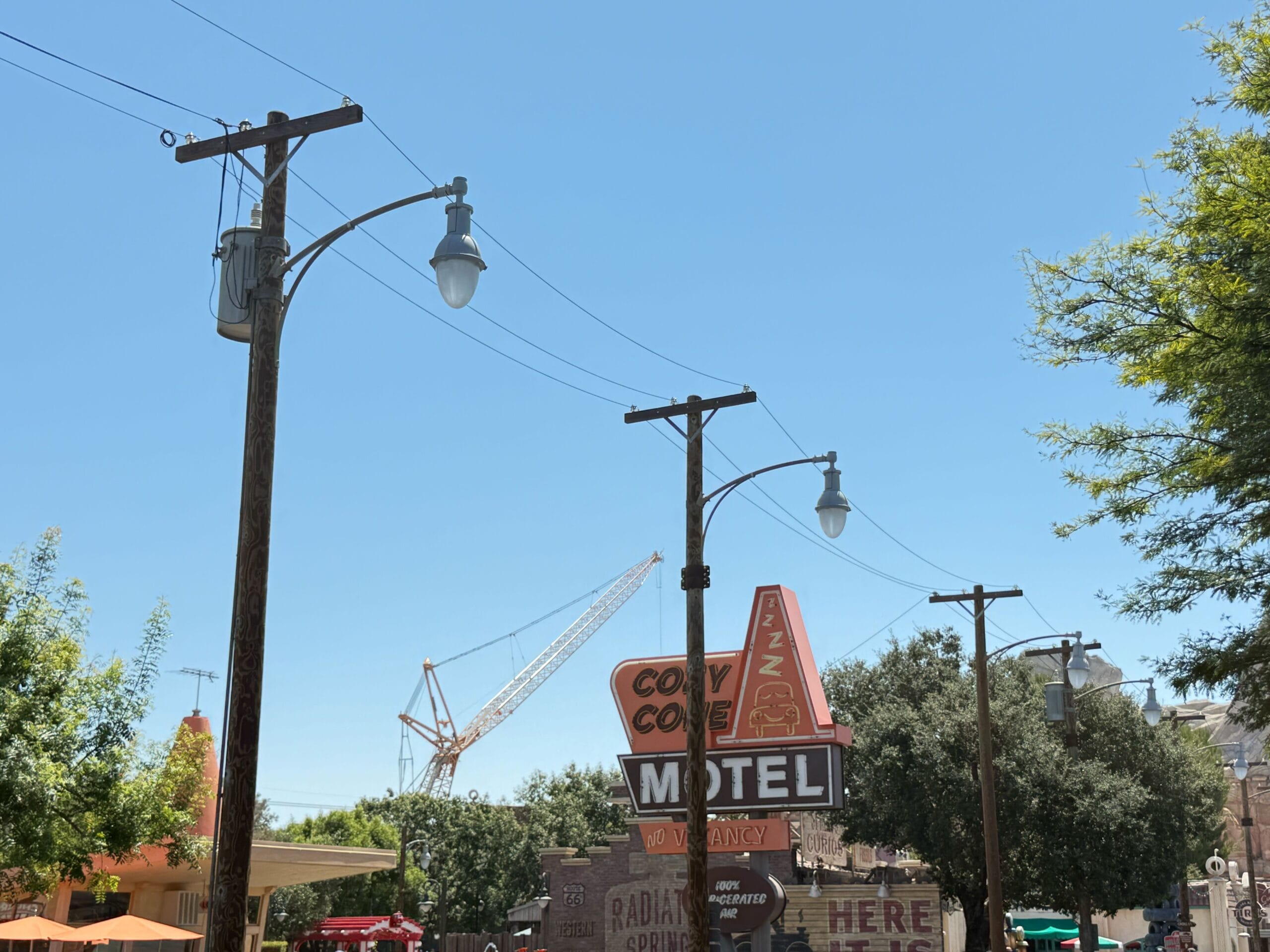 The Cozy Cone and power lines under a clear blue sky with a crane in the background for Avengers Campus Construction.
