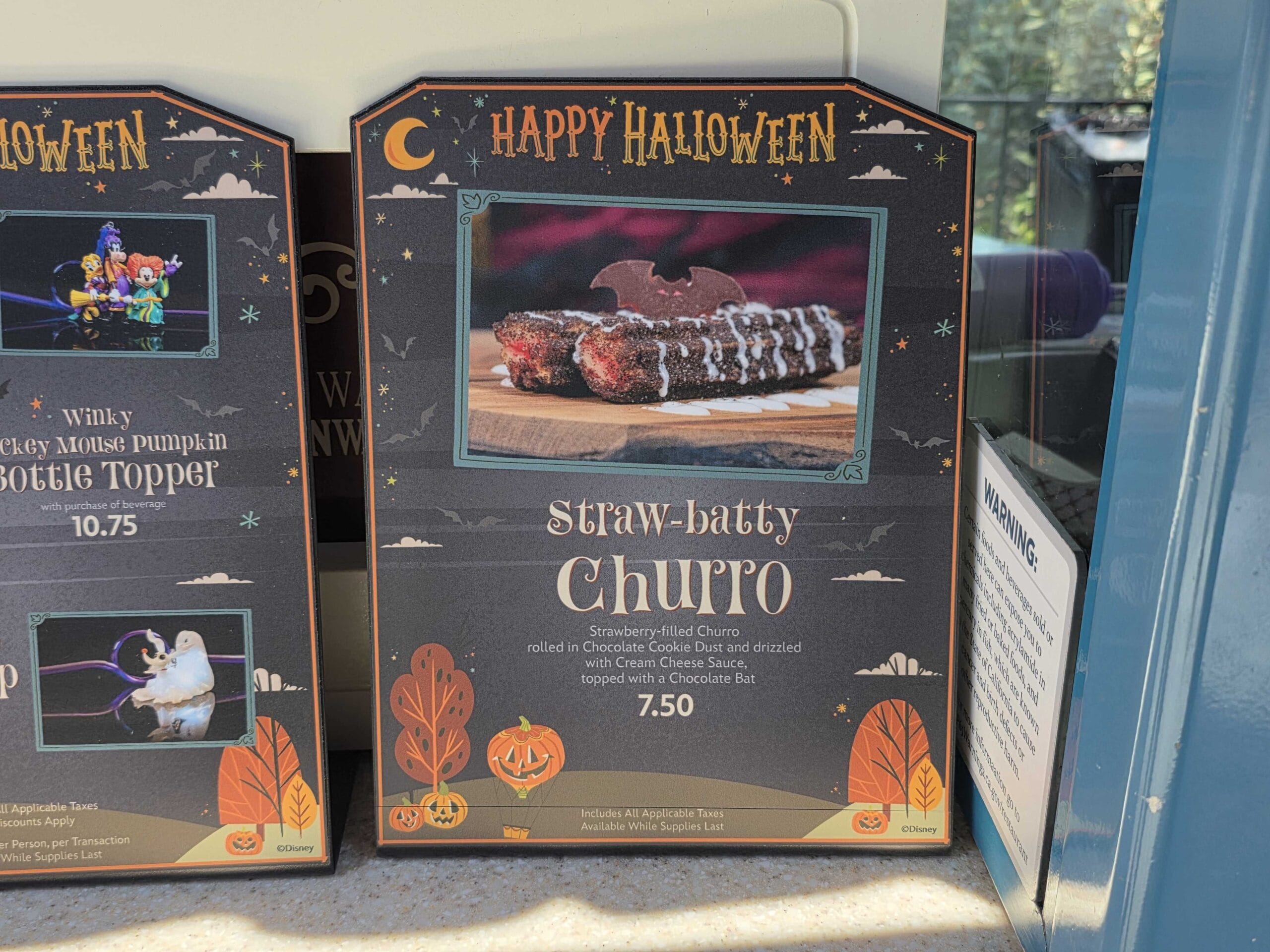 A Disneyland Halloween Churros sign for "Straw-batty Churro" topped with a chocolate bat, just $7.50.