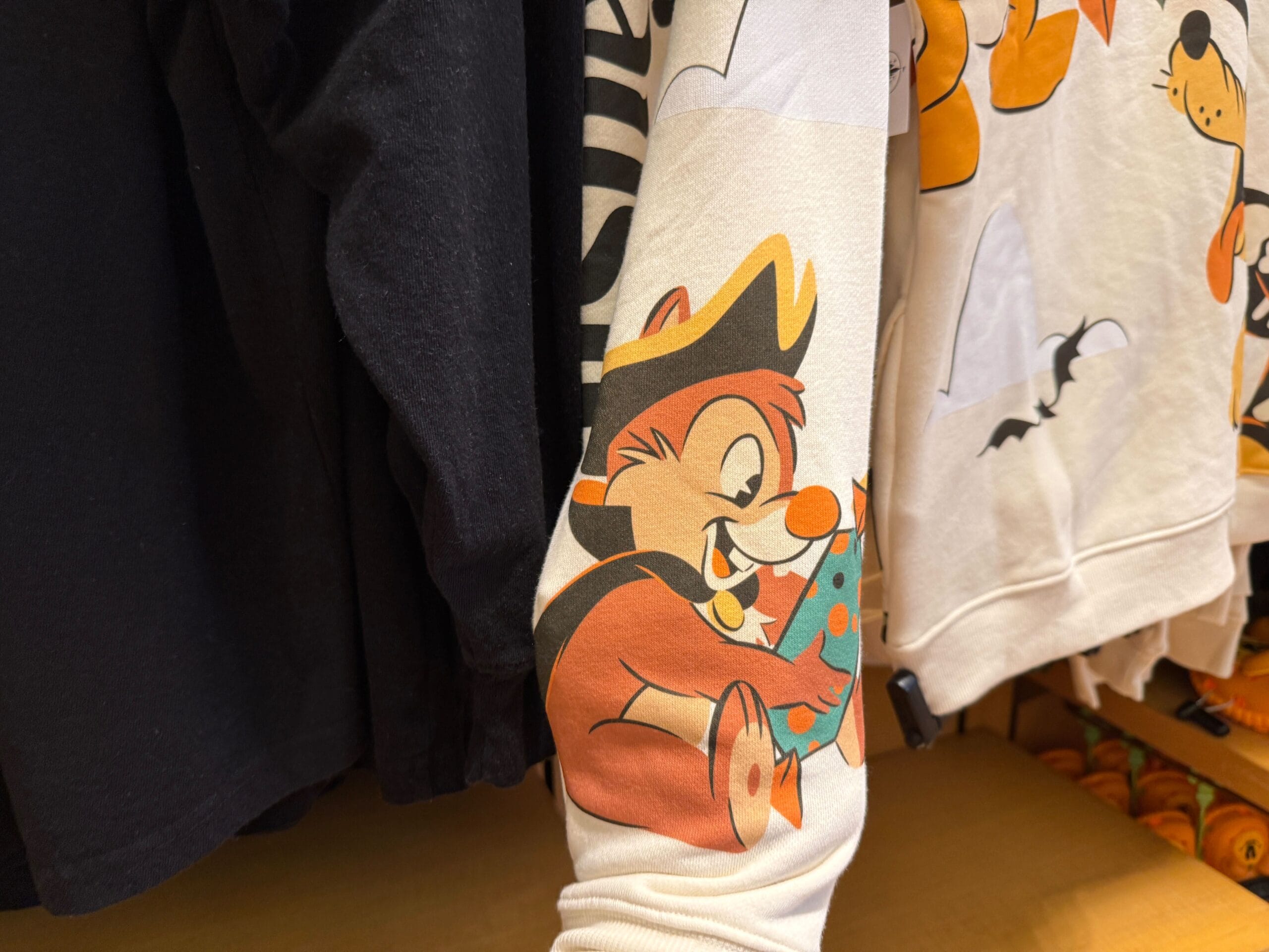 Long-sleeve shirt with a cartoon chipmunk pirate holding candy—fun Disneyland Halloween merchandise among other clothes.