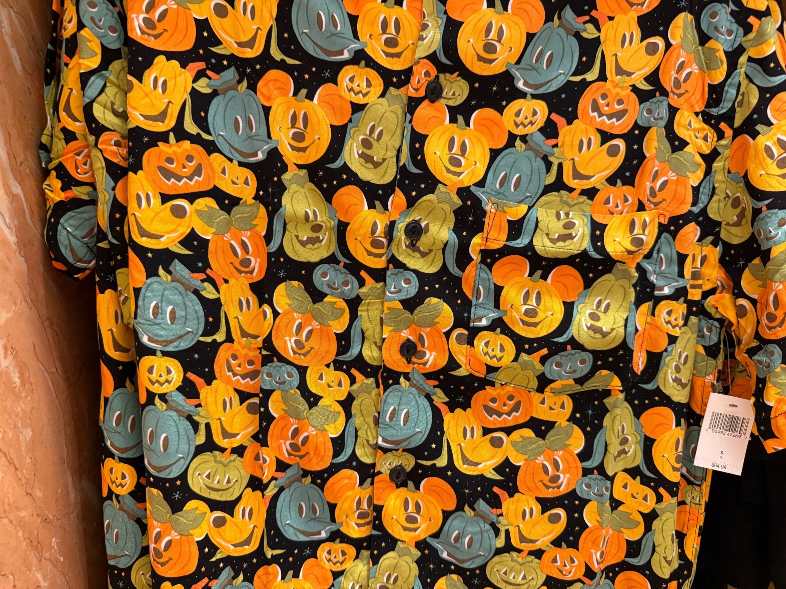 Disneyland Halloween merchandise: shirt with colorful Mickey Mouse pumpkin faces on a black, starry background.