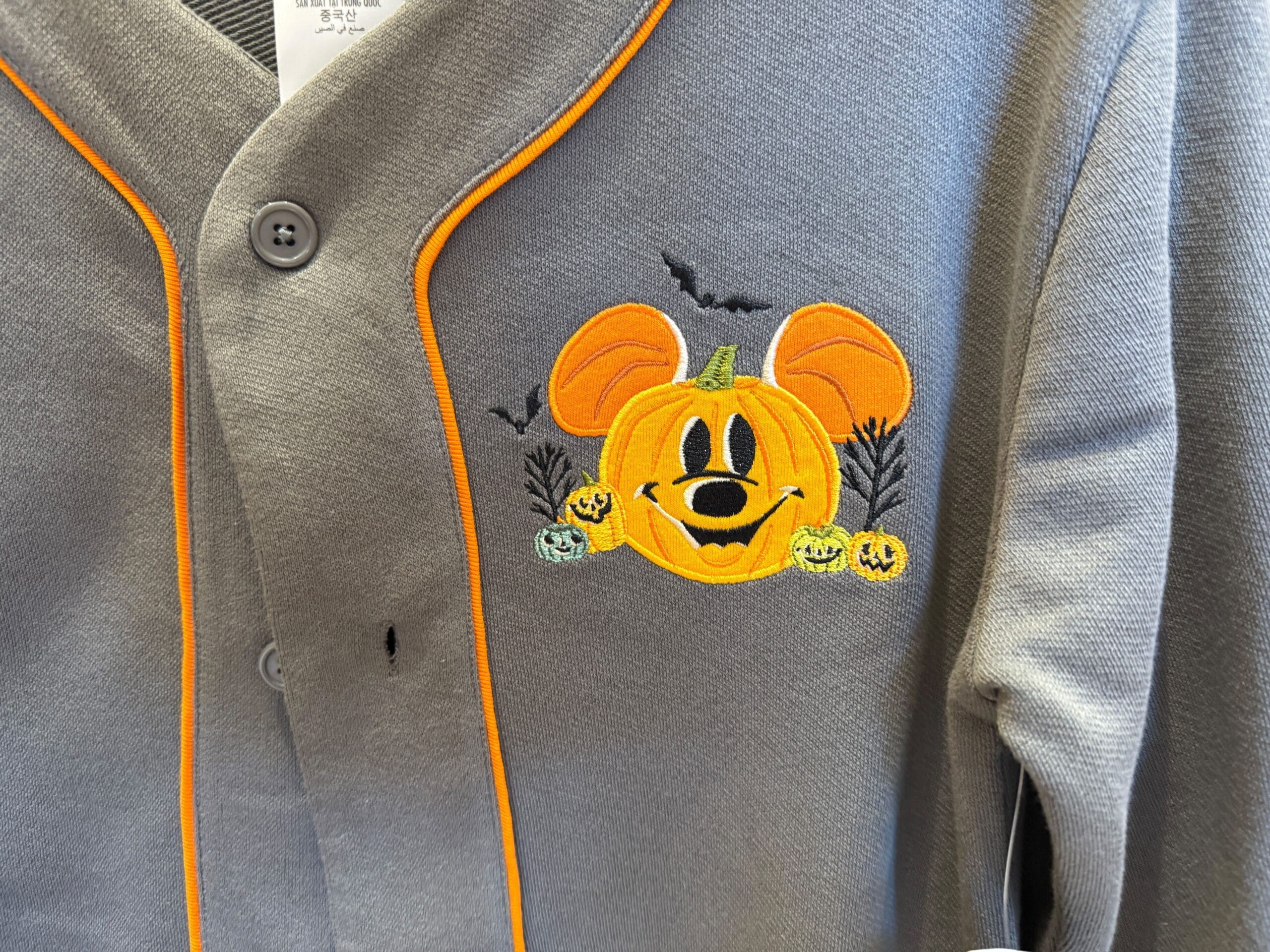 Gray shirt with Halloween-themed embroidery, perfect Disneyland Halloween merchandise featuring a Mickey Mouse pumpkin.