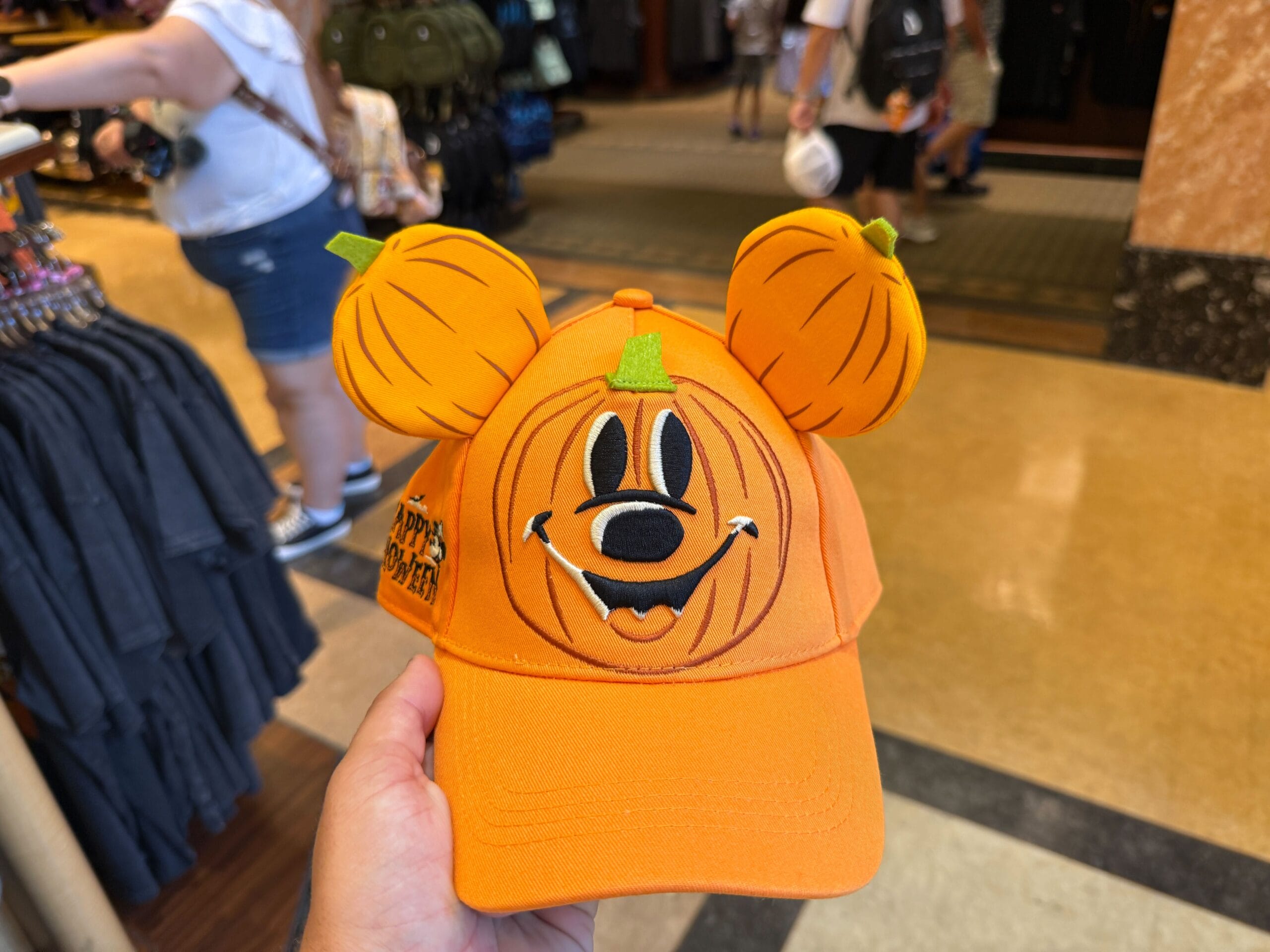 A Disneyland orange hat featuring Mickey Mouse’s pumpkin face and pumpkin ears, perfect Halloween merchandise.