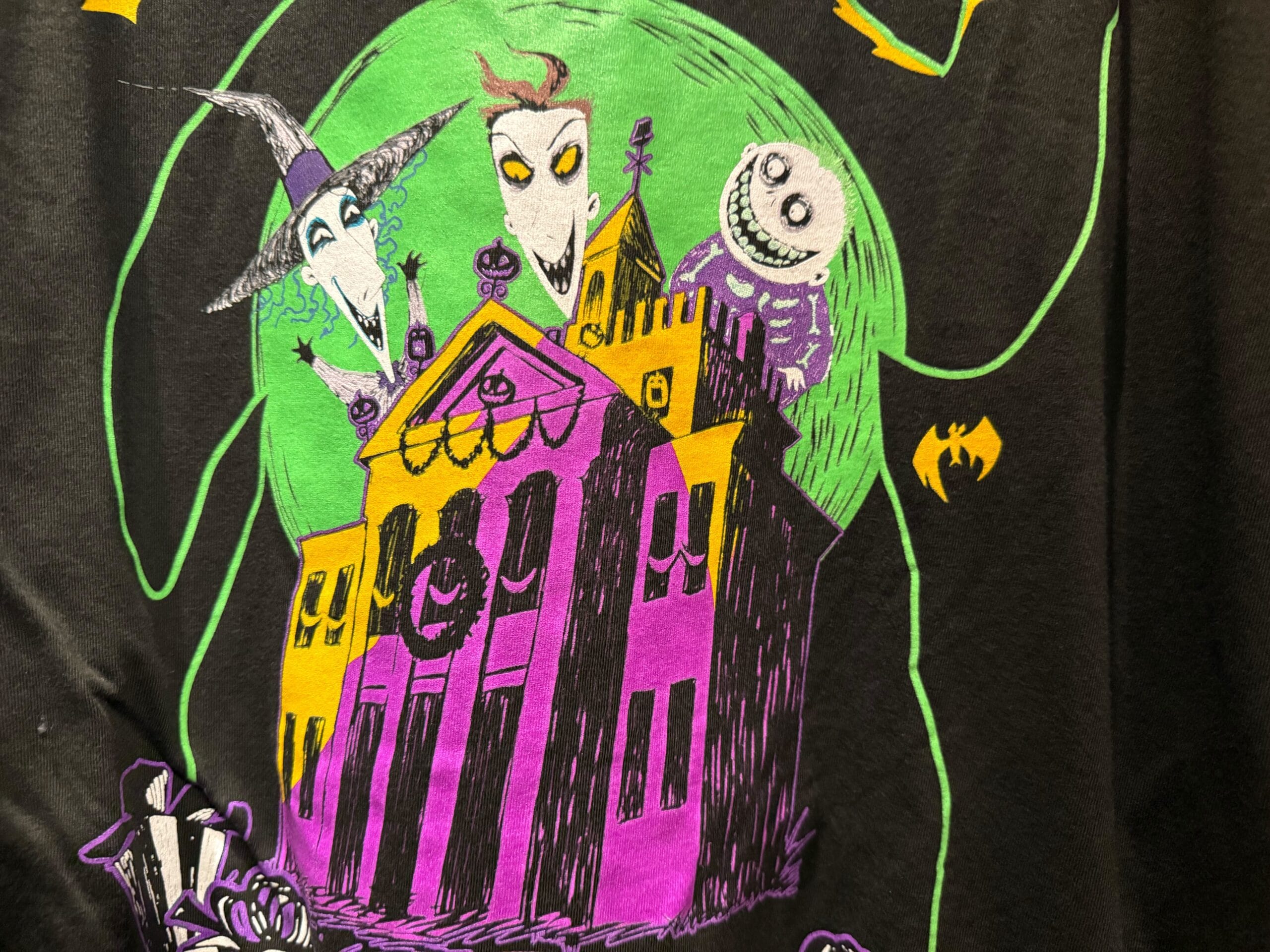 Cartoonish Haunted Mansion Holiday house with three spooky characters, green moon, and yellow bat on the right.