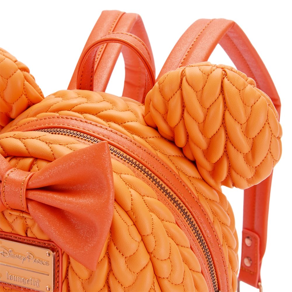 Close-up of a Disney Store orange backpack with quilted scales, mouse ears, and a bow from the Pumpkin Spice Collection.