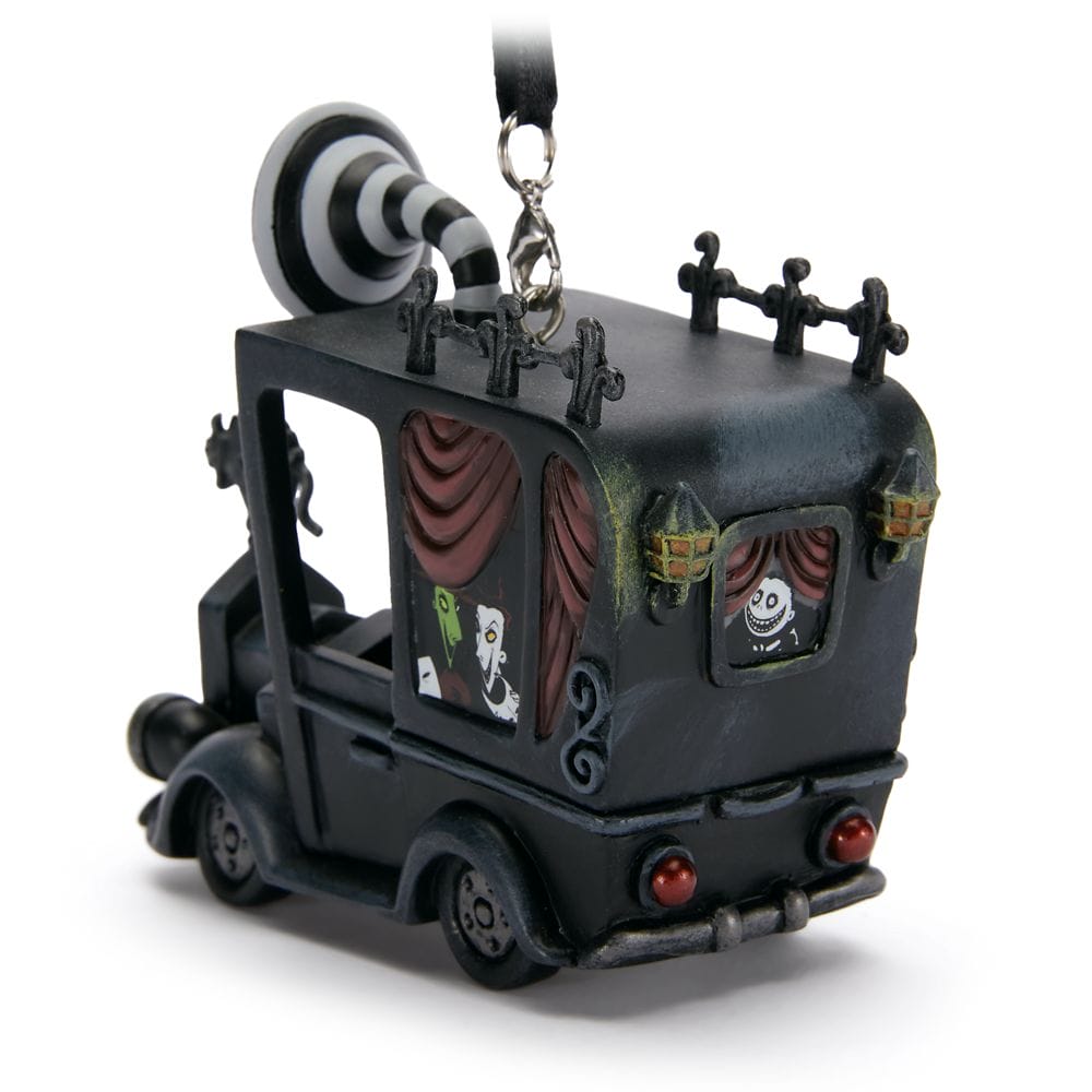 A black hearse ornament with striped roof, red curtains, and cartoonish skeleton figures inside, hanging from a loop.