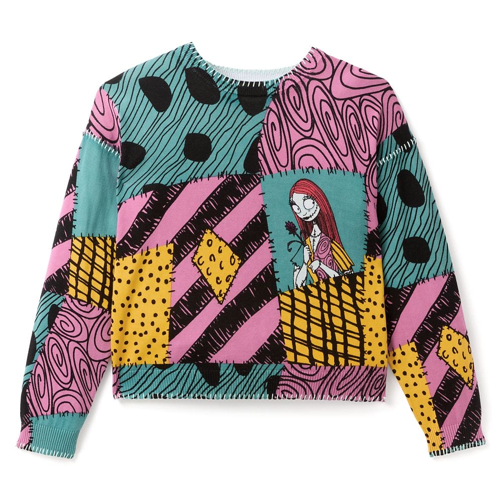 Colorful patchwork sweater with teal, pink, yellow, and black patterns featuring a cartoon girl holding a flower on the chest.
