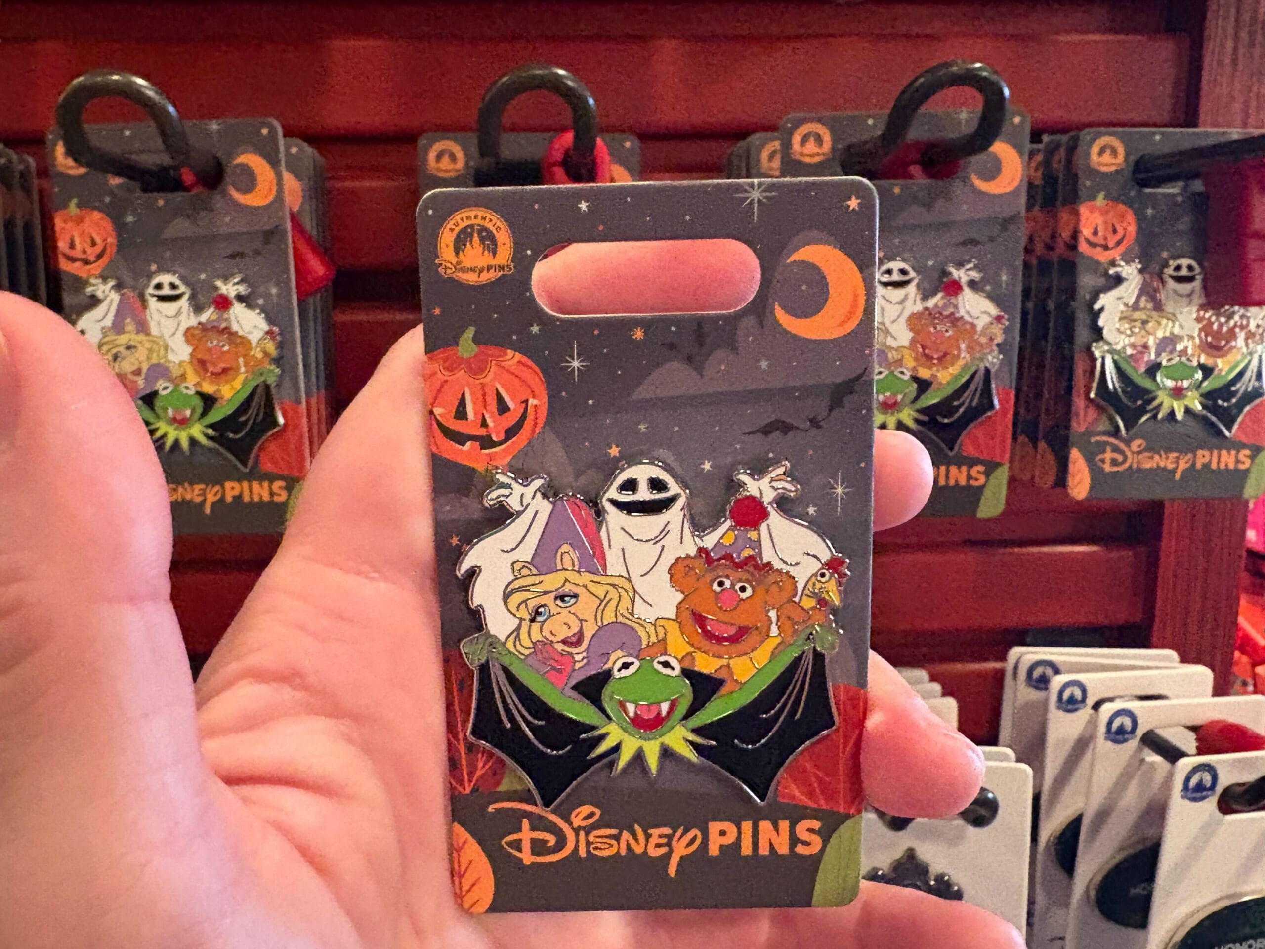 Hand holds a Walt Disney World Halloween pin with Kermit, Miss Piggy, Fozzie & Animal in costumes—2025 merchandise preview.