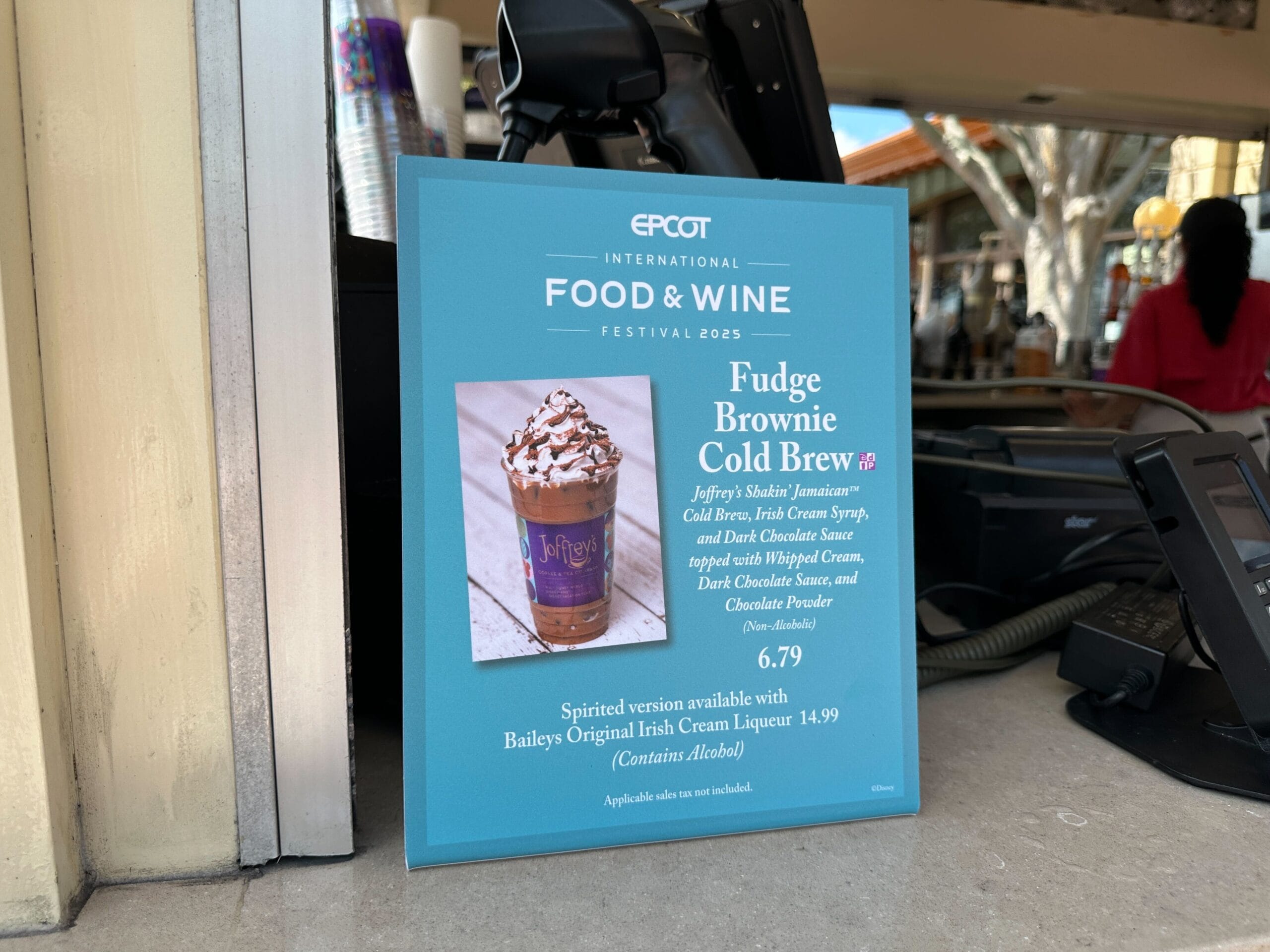A sign at EPCOT advertises New Food & Wine Fudge Brownie Cold Brew with a photo of the drink and its $6.79 price.