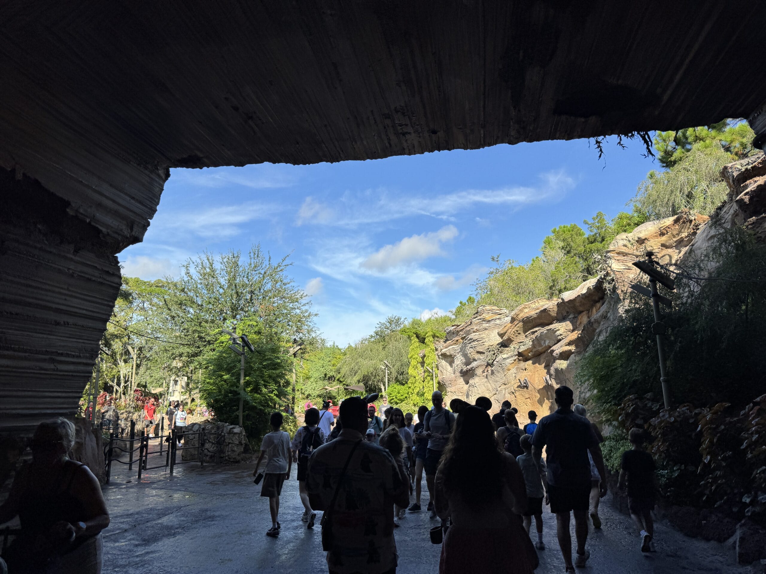 A photo report from 2025 shows people walking from a dark cave into sunlight at Hollywood Studios.
