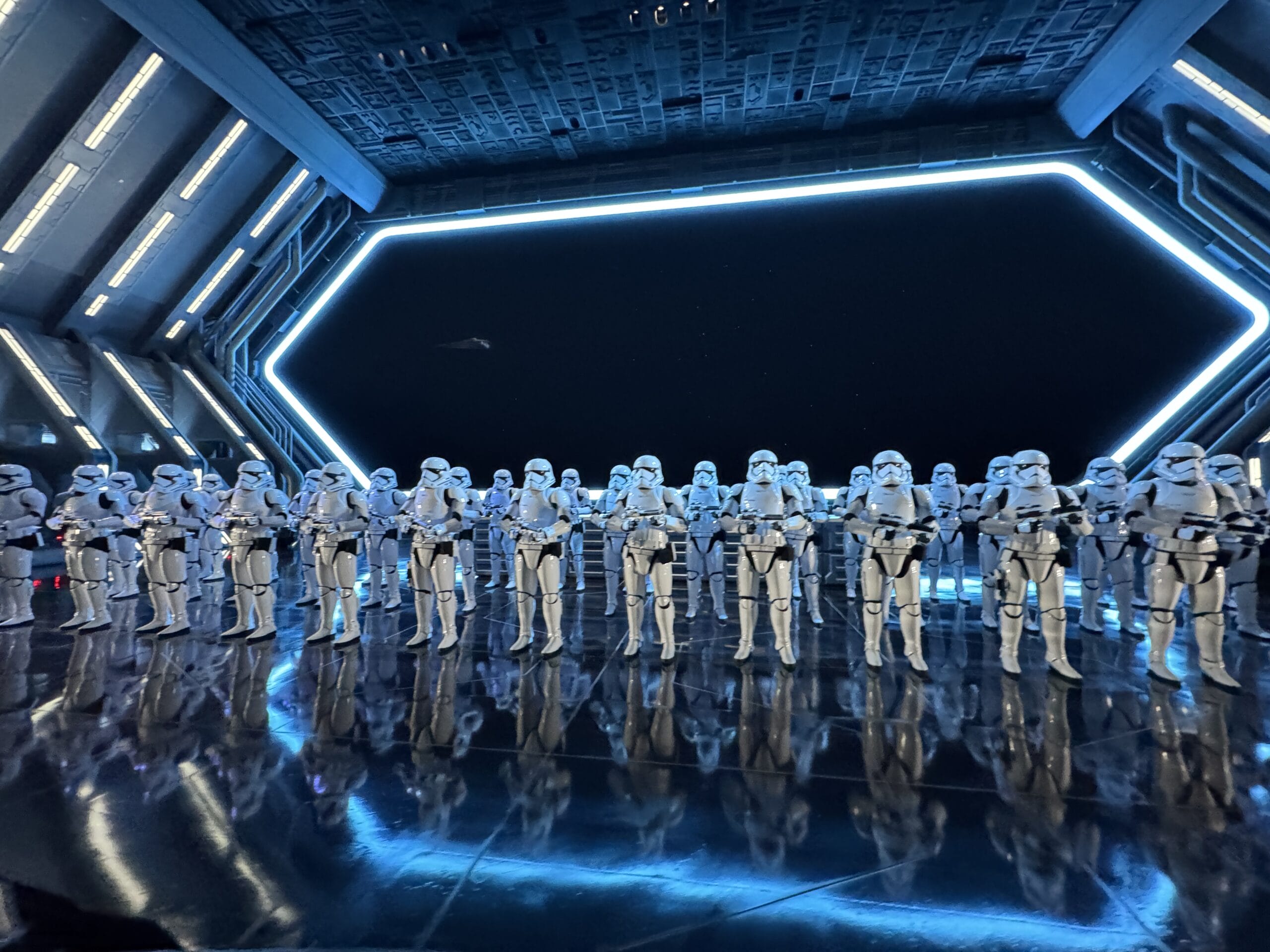 A group of stormtroopers stands in formation inside a futuristic Hollywood Studios spaceship hangar for a 2025 photo report.