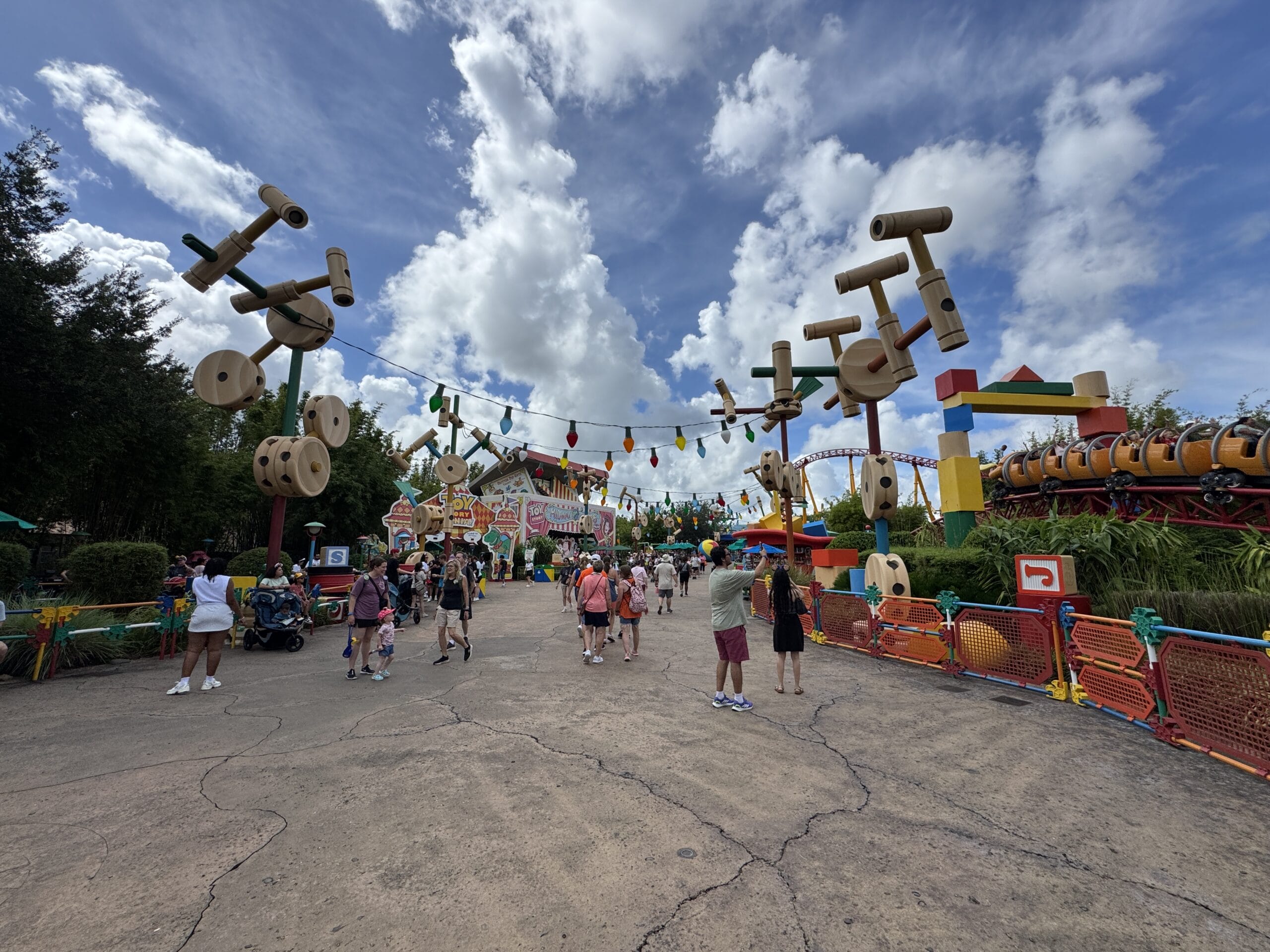 Visitors stroll through a vibrant, toy-themed area at Hollywood Studios in this 2025 photo report.
