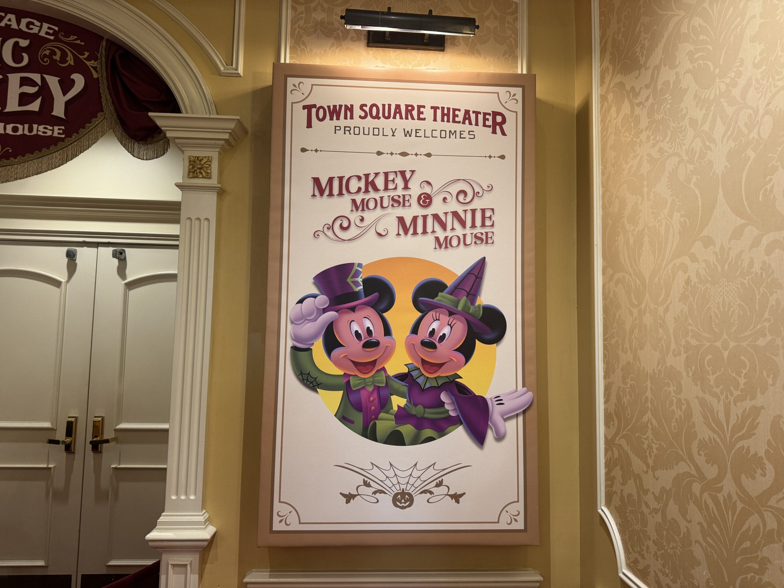 A sign at Town Square Theater welcomes guests to Mickey's Not So Scary Party with Mickey and Minnie in Halloween costumes.