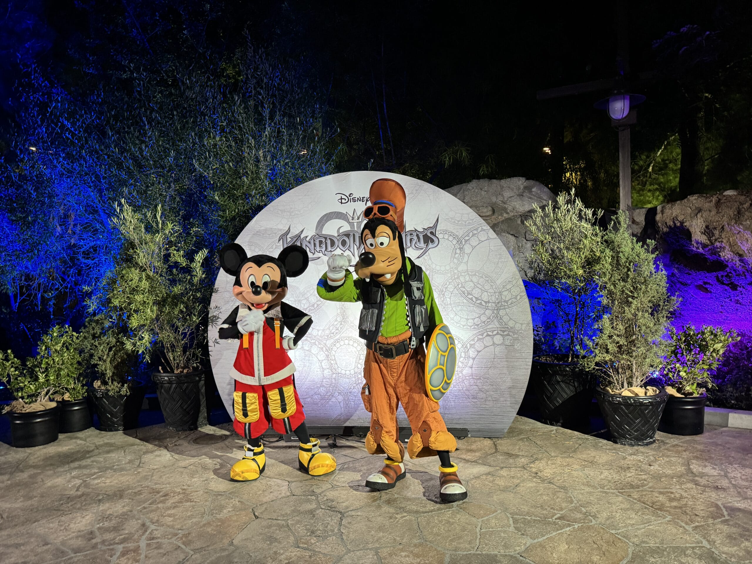 Mickey Mouse and Goofy in Kingdom Hearts costumes pose at night for a photo report from Oogie Boogie Bash.