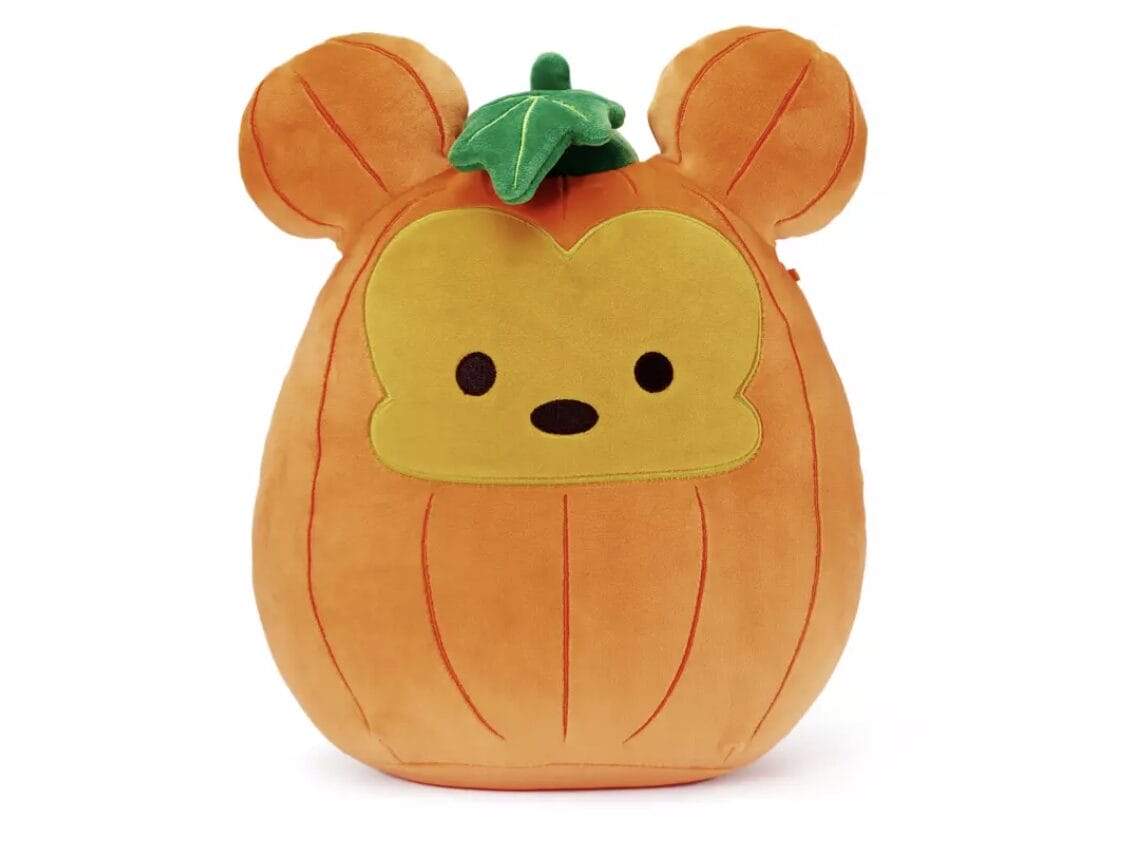 A plush toy shaped like a pumpkin with bear ears, inspired by Disney Squishmallows and a cute face with a green leaf.