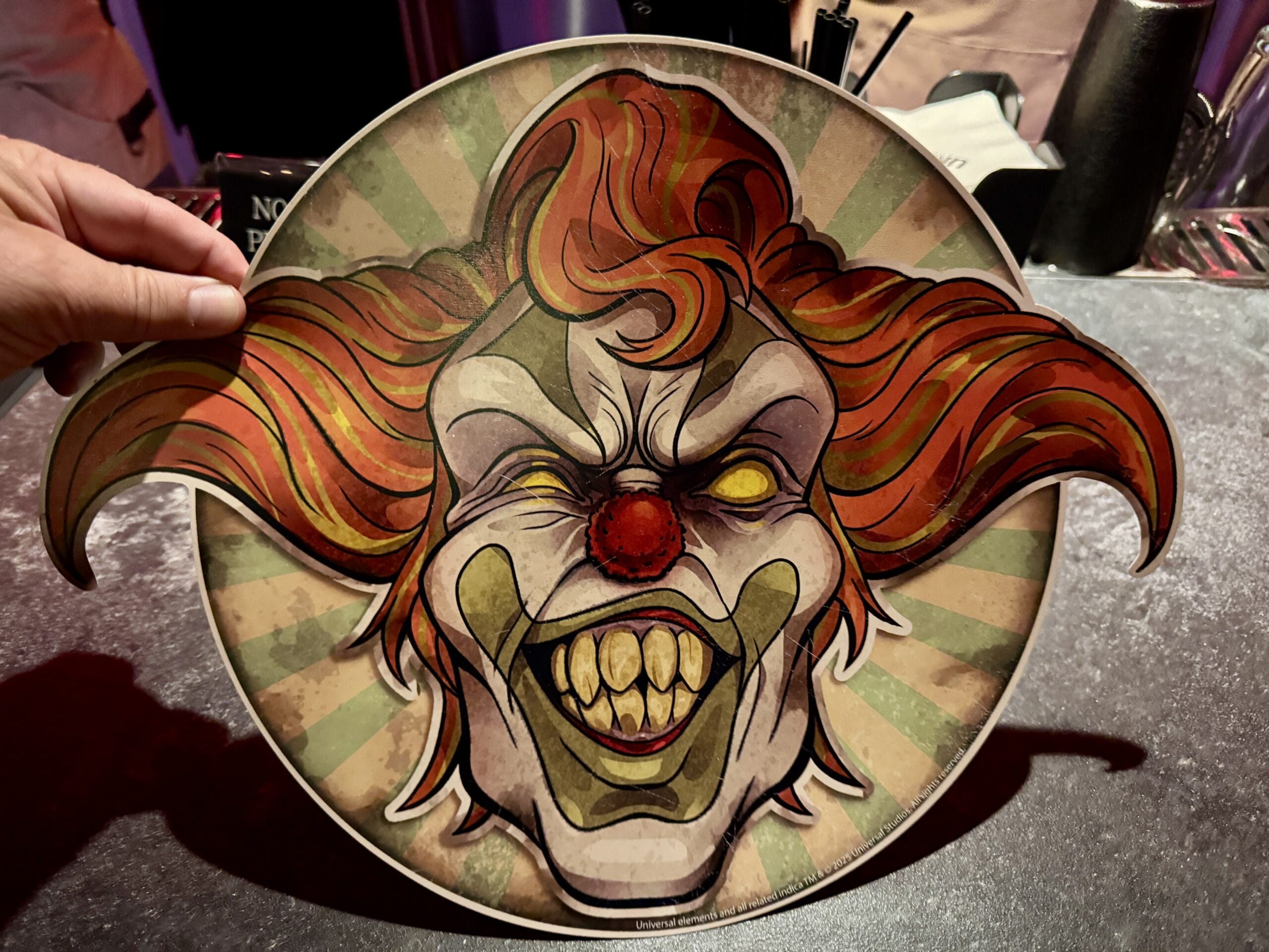 A cartoonish, creepy clown face with wild orange hair and yellow teeth lurks at Jack's Alley Bar in Las Vegas.