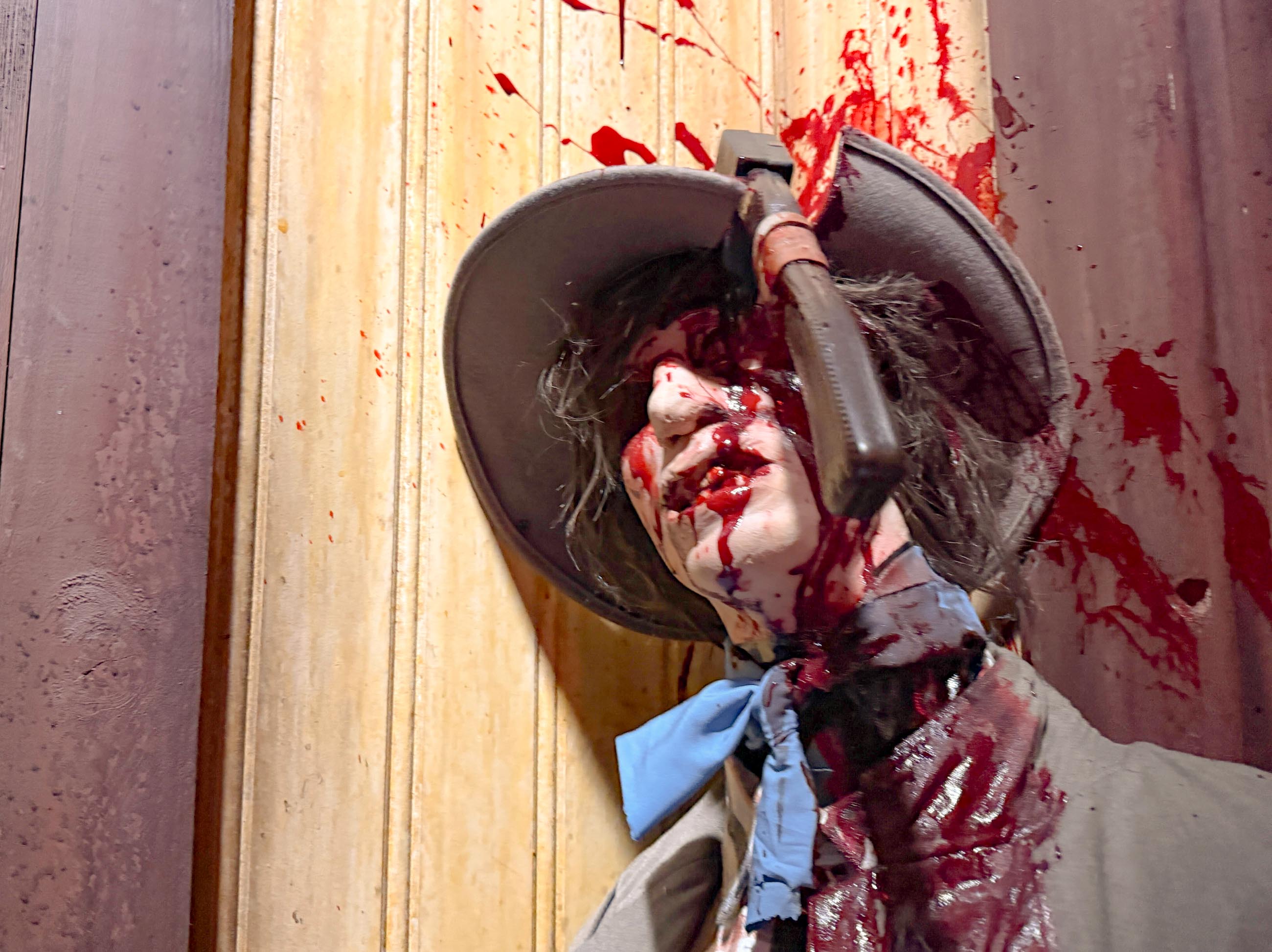 A mannequin with a hat, stabbed and splattered in fake blood, channels flesh-eating demons like those in HHN houses.