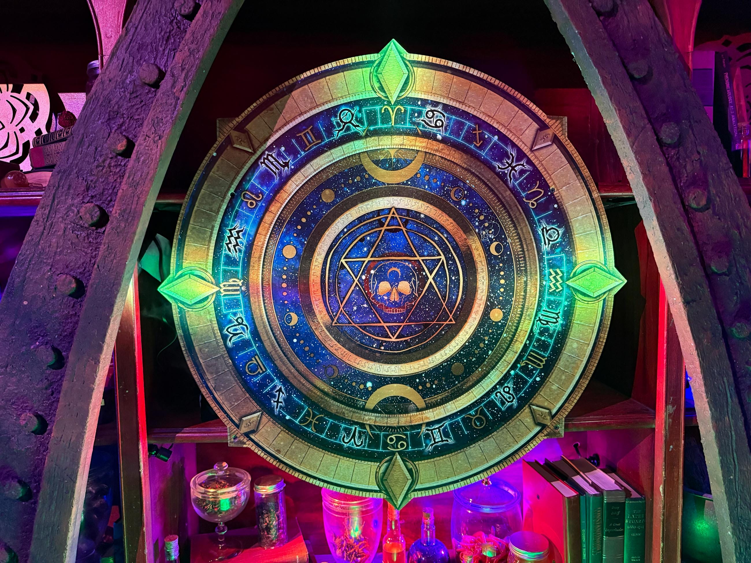 A glowing, circular magical symbol with mysterious runes, as if prepared by Sorority Witches among books and potion bottles.
