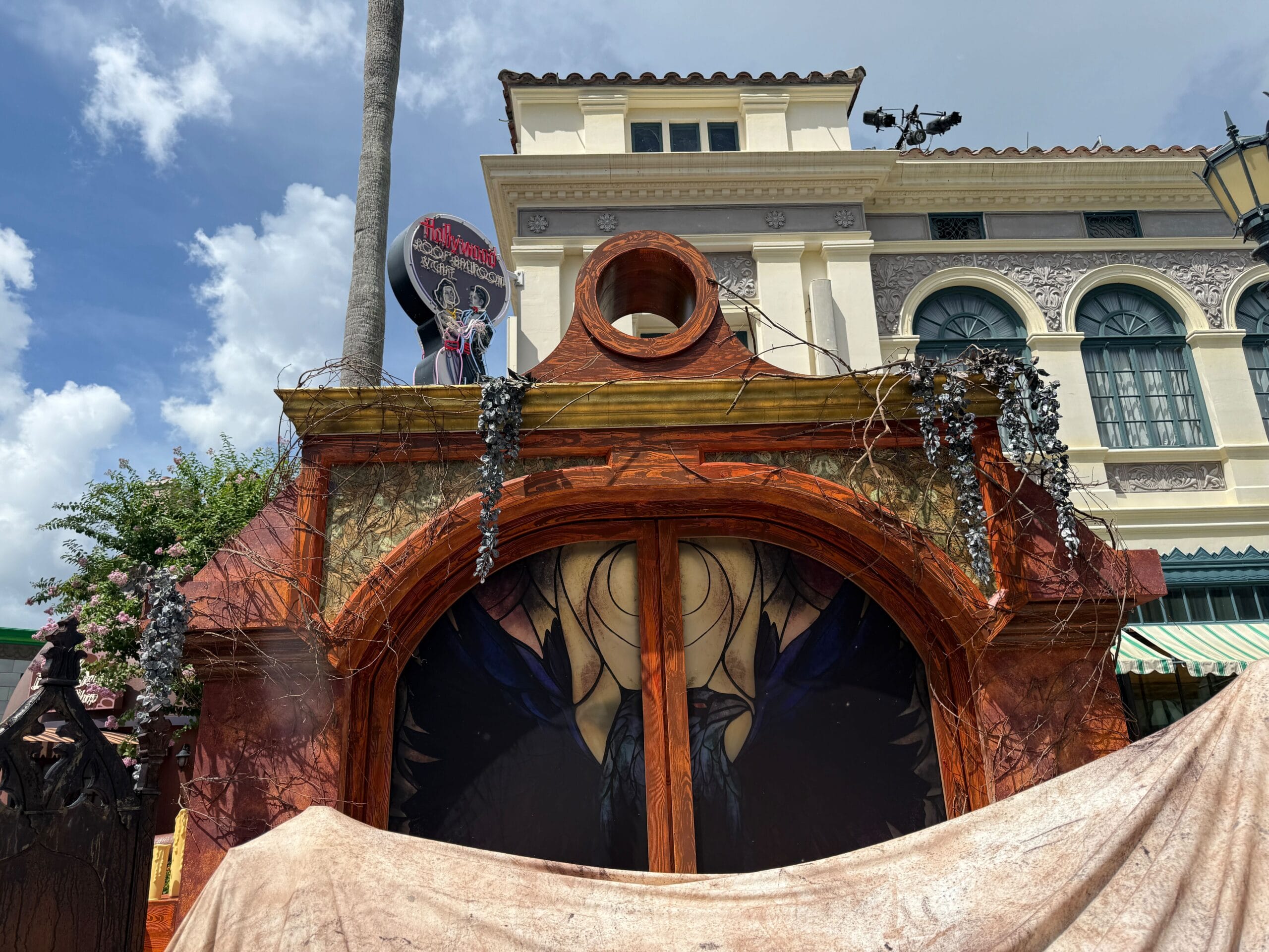 A spooky, ornate archway with dark decorations evokes Halloween Horror Nights 34 under a partly cloudy sky.