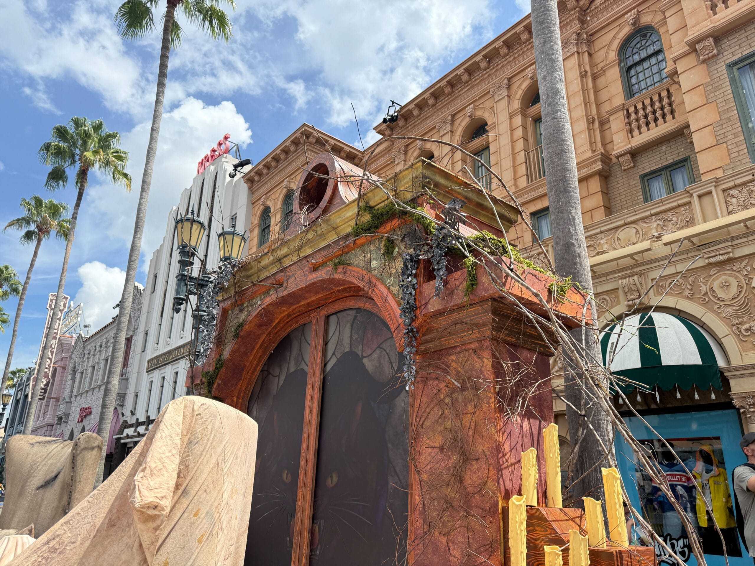 Close-up of a movie set facade with weathered arch and props, echoing the style of Halloween Horror Nights 34.