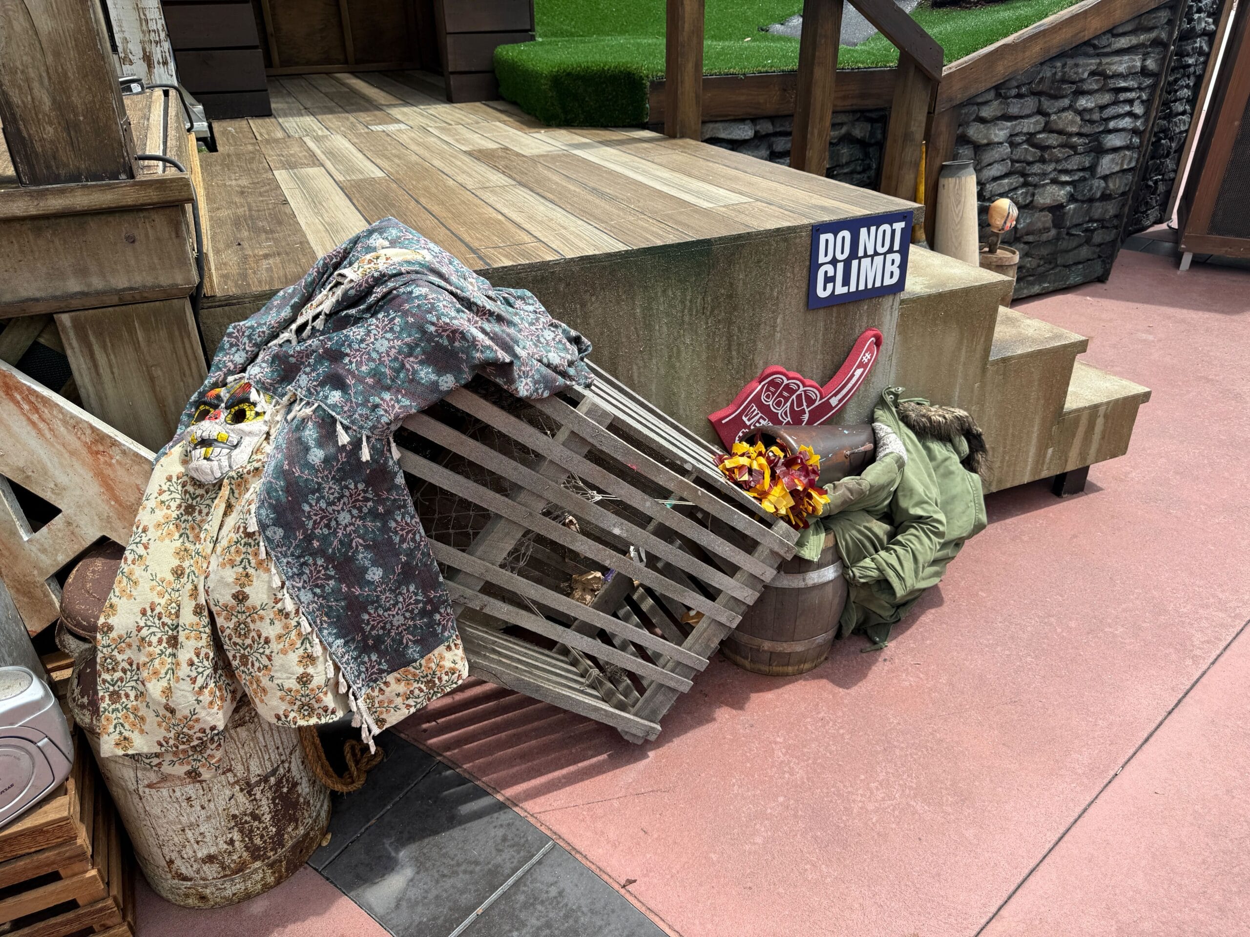 A “Do Not Climb” sign is by stairs, near Clown Cafe props and crates—perfect for Halloween Horror Nights 34.
