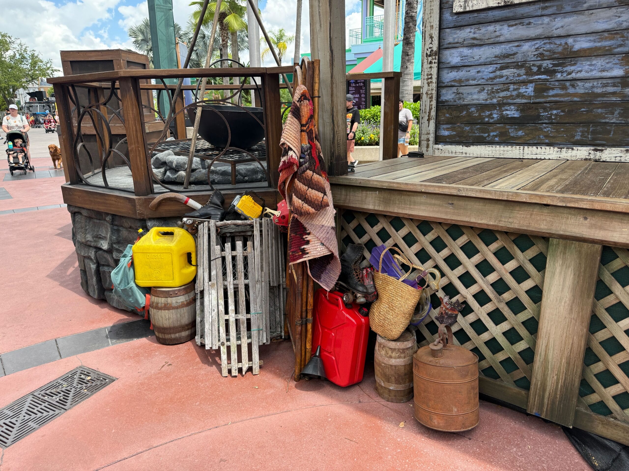 Assorted props like jerry cans, baskets, and crates stacked by a wooden stage at Halloween Horror Nights 34.