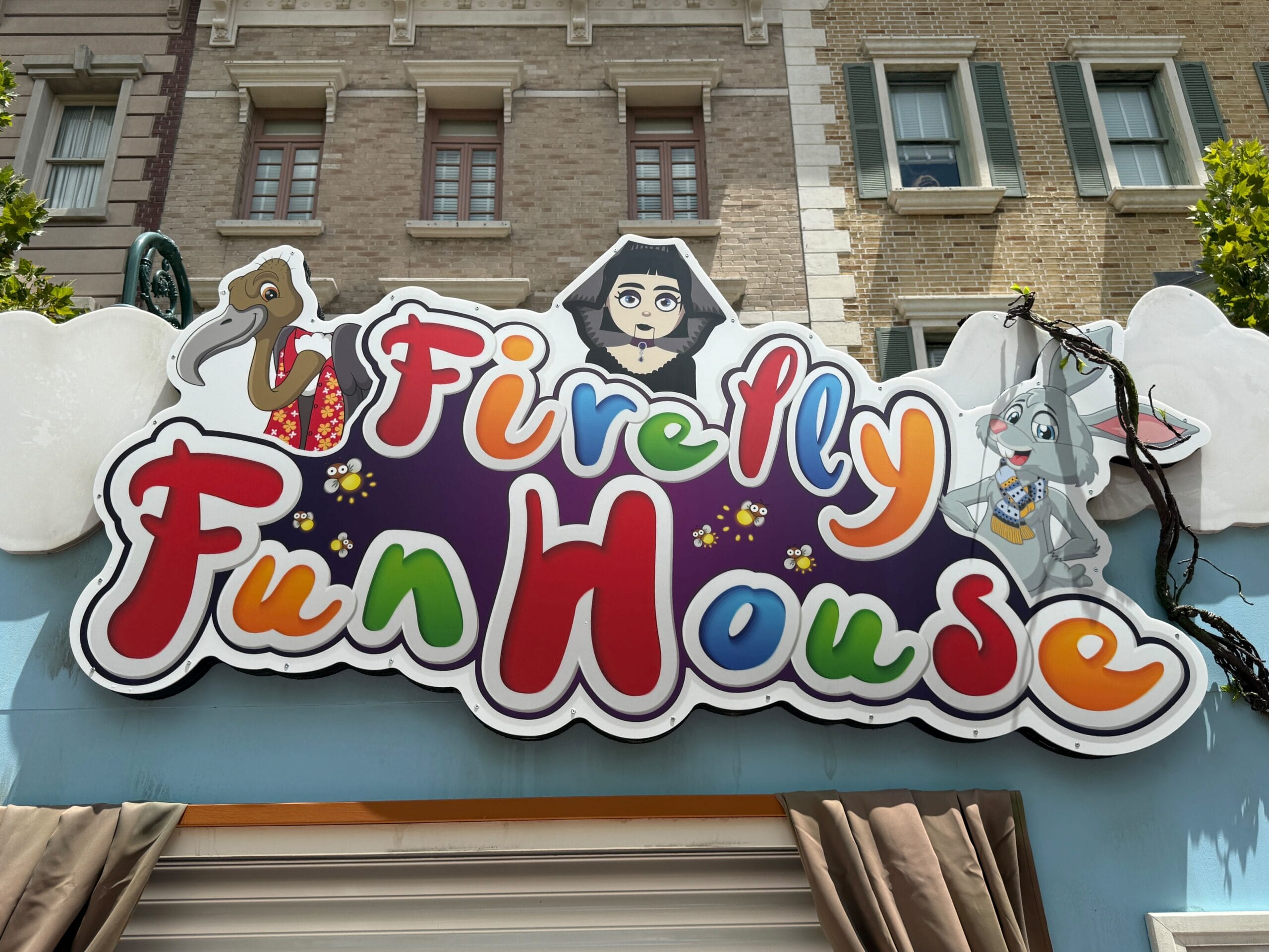 Colorful Firefly Fun House Sign with cartoon characters above an entrance, featured at Halloween Horror Nights 34.