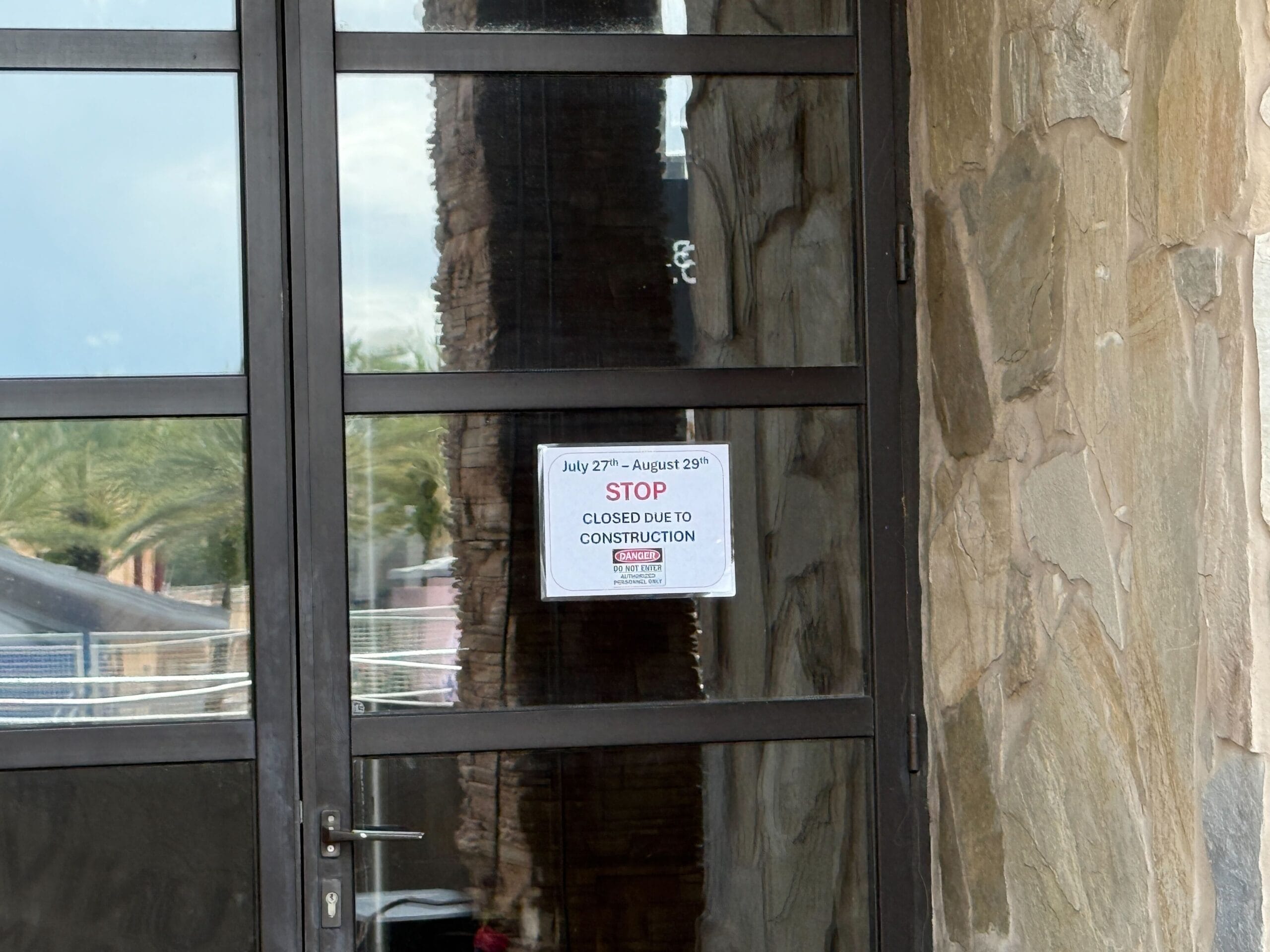 A glass door with a sign reading "STOP CLOSED DUE TO CONSTRUCTION—Clown Cafe July 27th–August 29th.