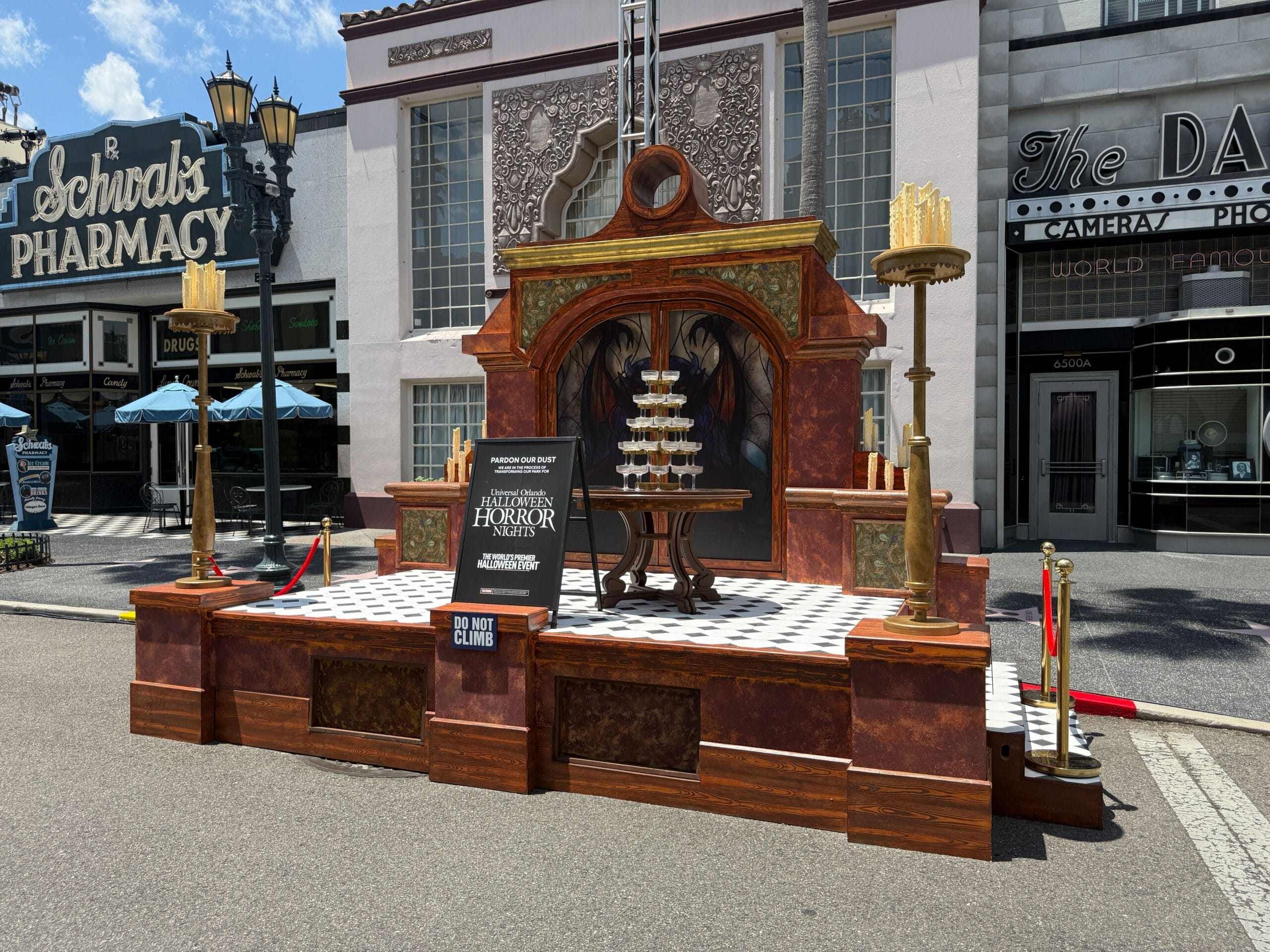A decorative stage display with a pyramid of glasses and a sign for "Universal Orlando's Halloween Horror Nights.