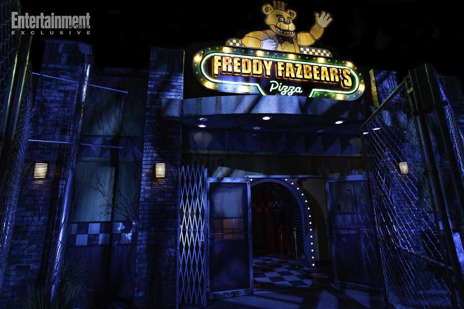 The entrance of Freddy Fazbear’s Pizza at night, glowing neon sign above, sets the eerie Five Nights at Freddy's scene.