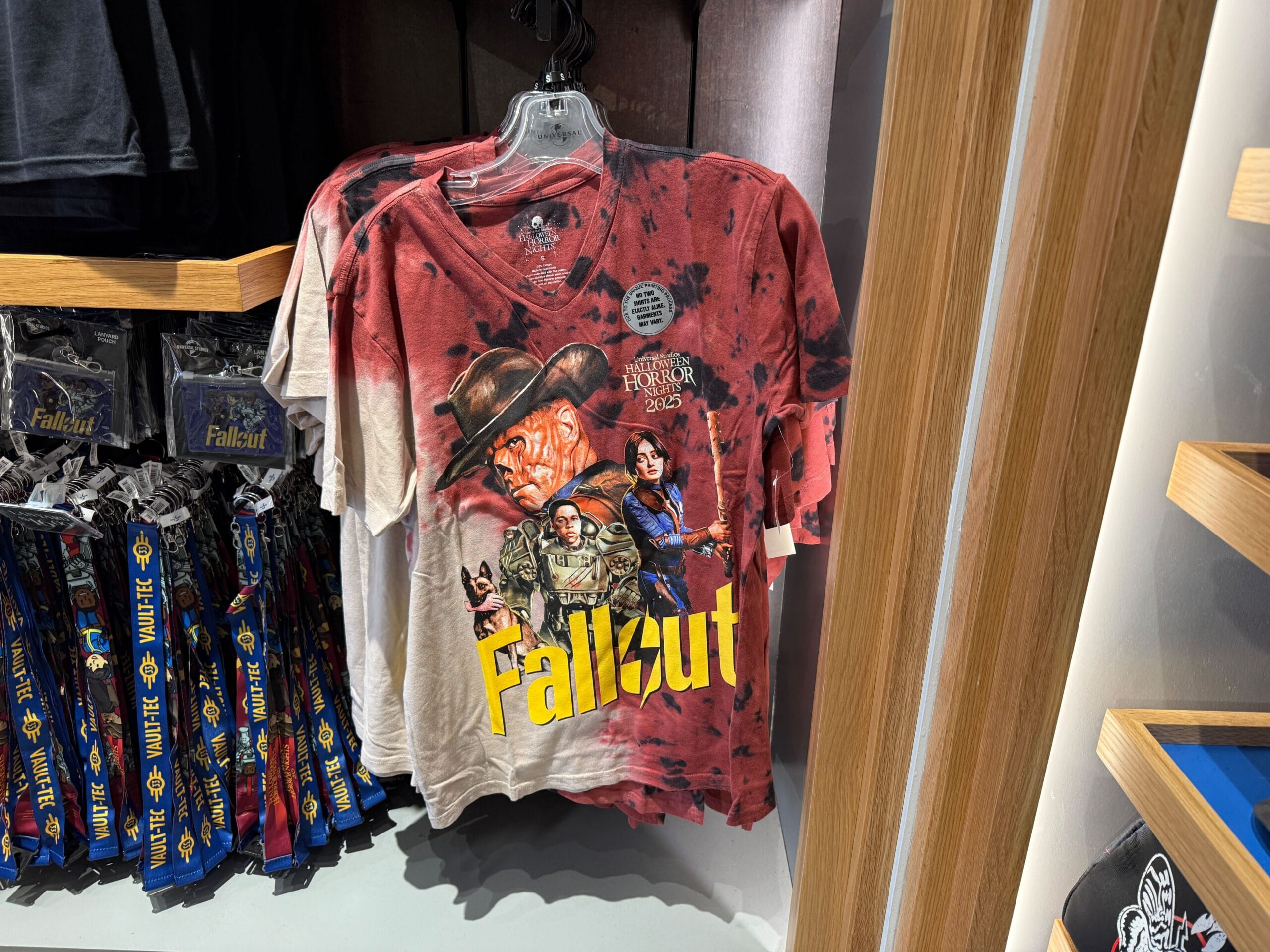 A Fallout-themed T-shirt with characters and logo hangs by Universal Orlando Resort’s Halloween Horror Nights Merchandise.