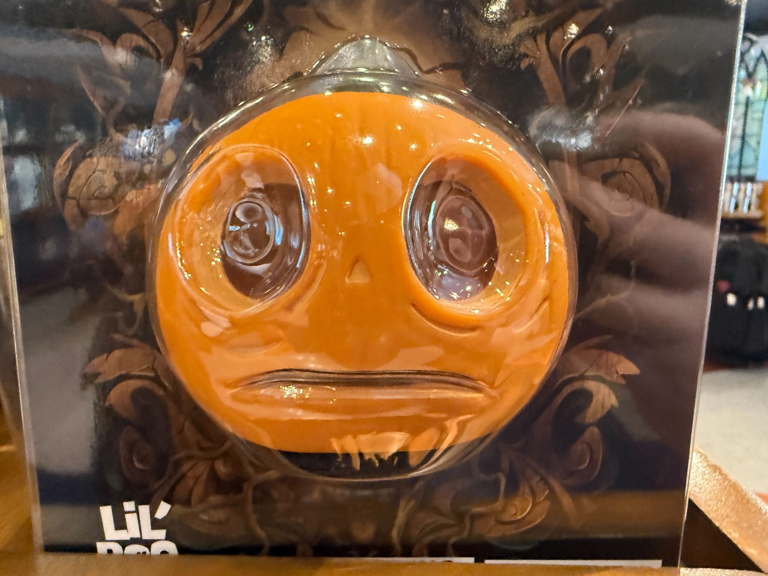 A sad, orange pumpkin face with large eyes and a frown—perfect for Halloween Horror Nights Merchandise fans.