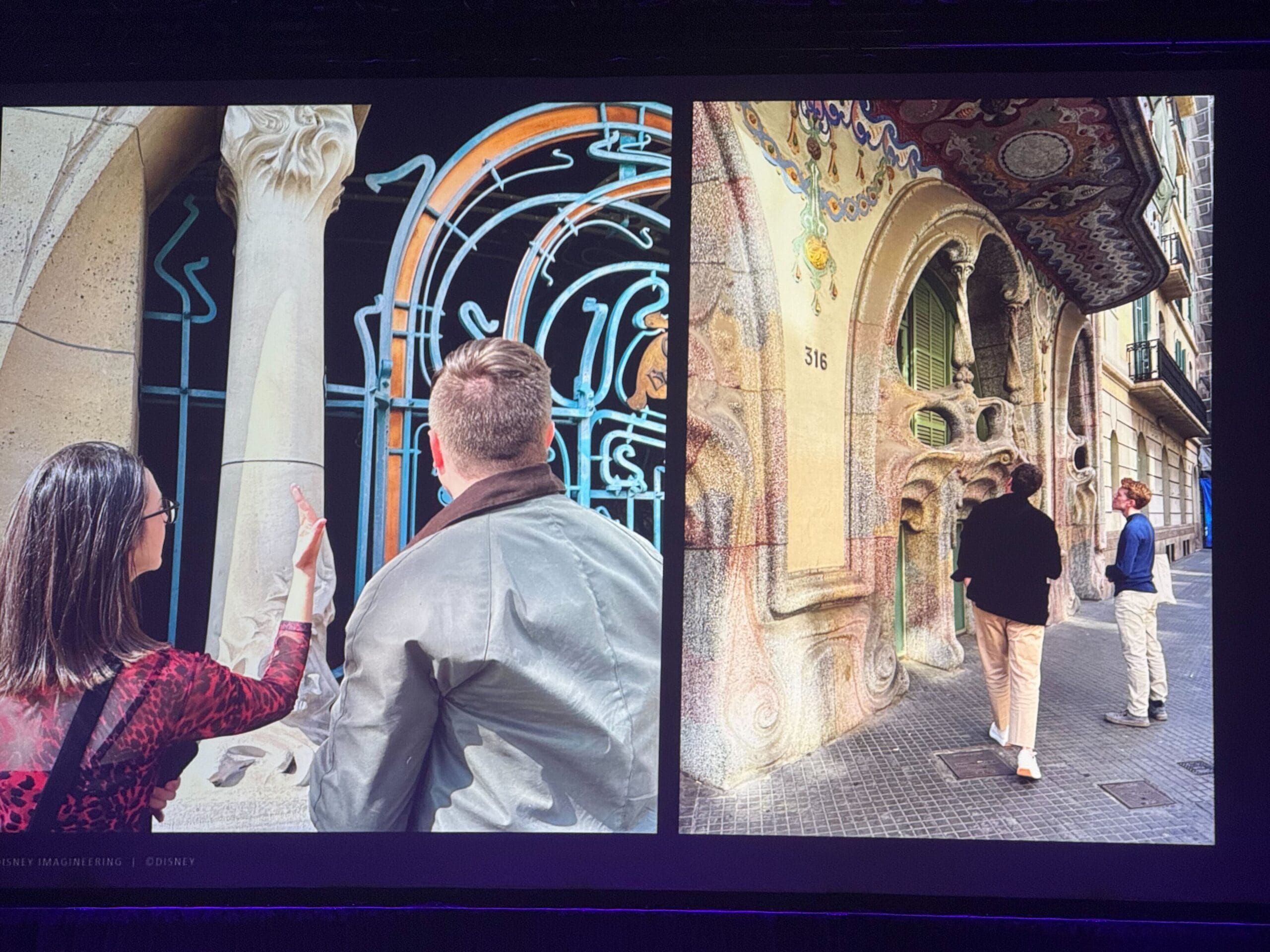 Two people admire intricate details crafted by Imagineers on an ornate building's facade in an urban setting.